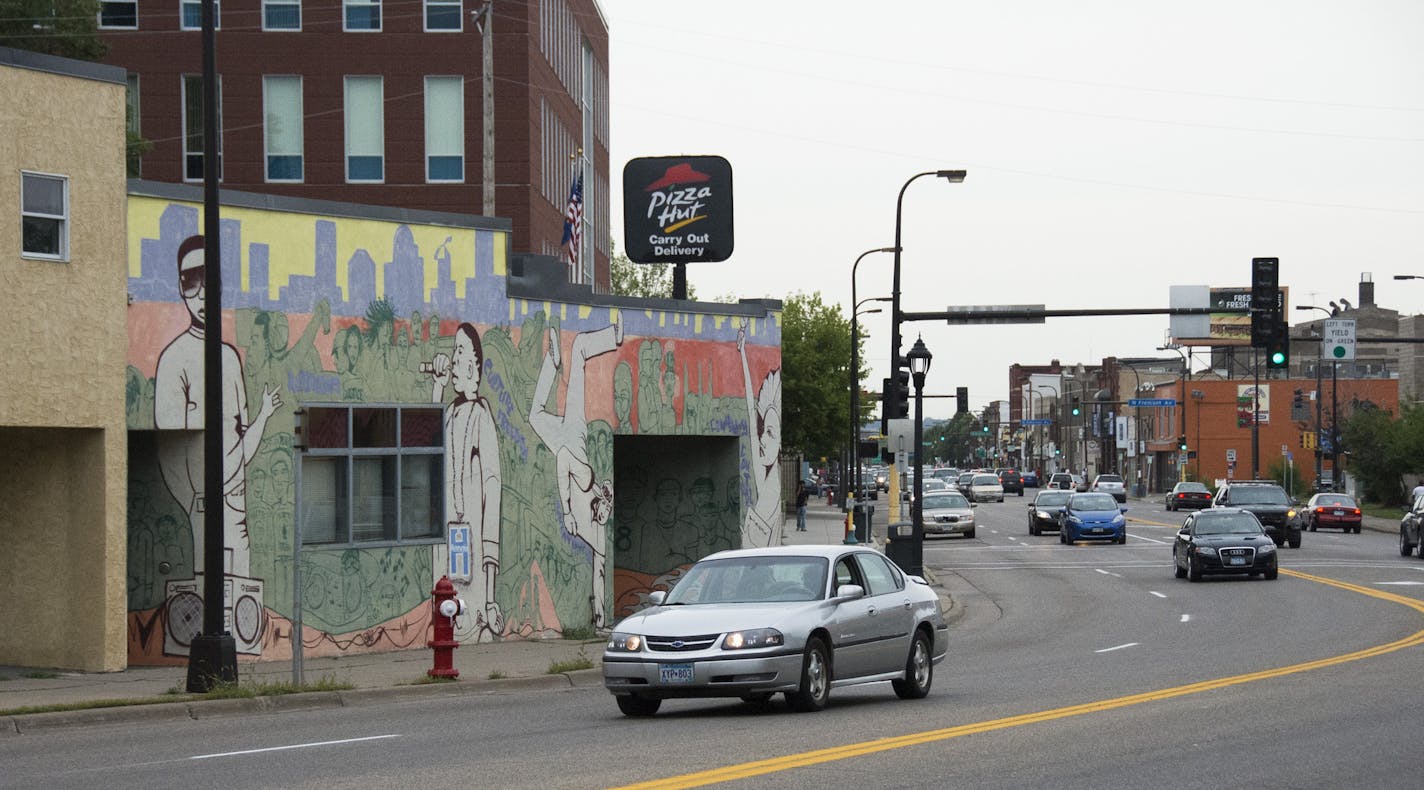 Cars drove past a Pizza Hut on West Broadway. With little agreement on how best to revitalize the street, it has remained a largely rundown, unwelcoming area.