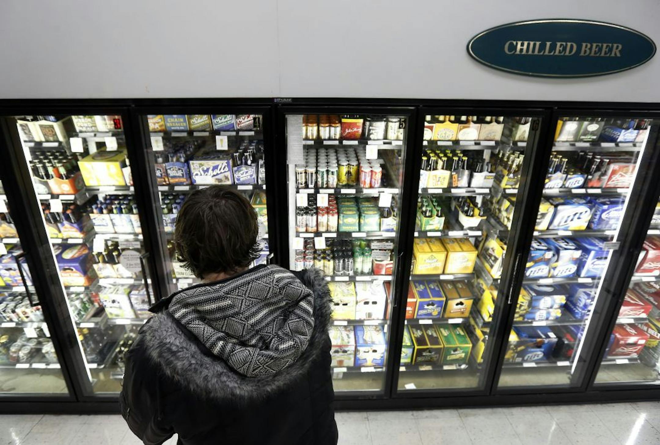 Christopher Hunt, 32, of Minneapolis shopped for beer at Surdyk's in northeast Minneapolis on Monday. Some stores are not eager to be open all week.
