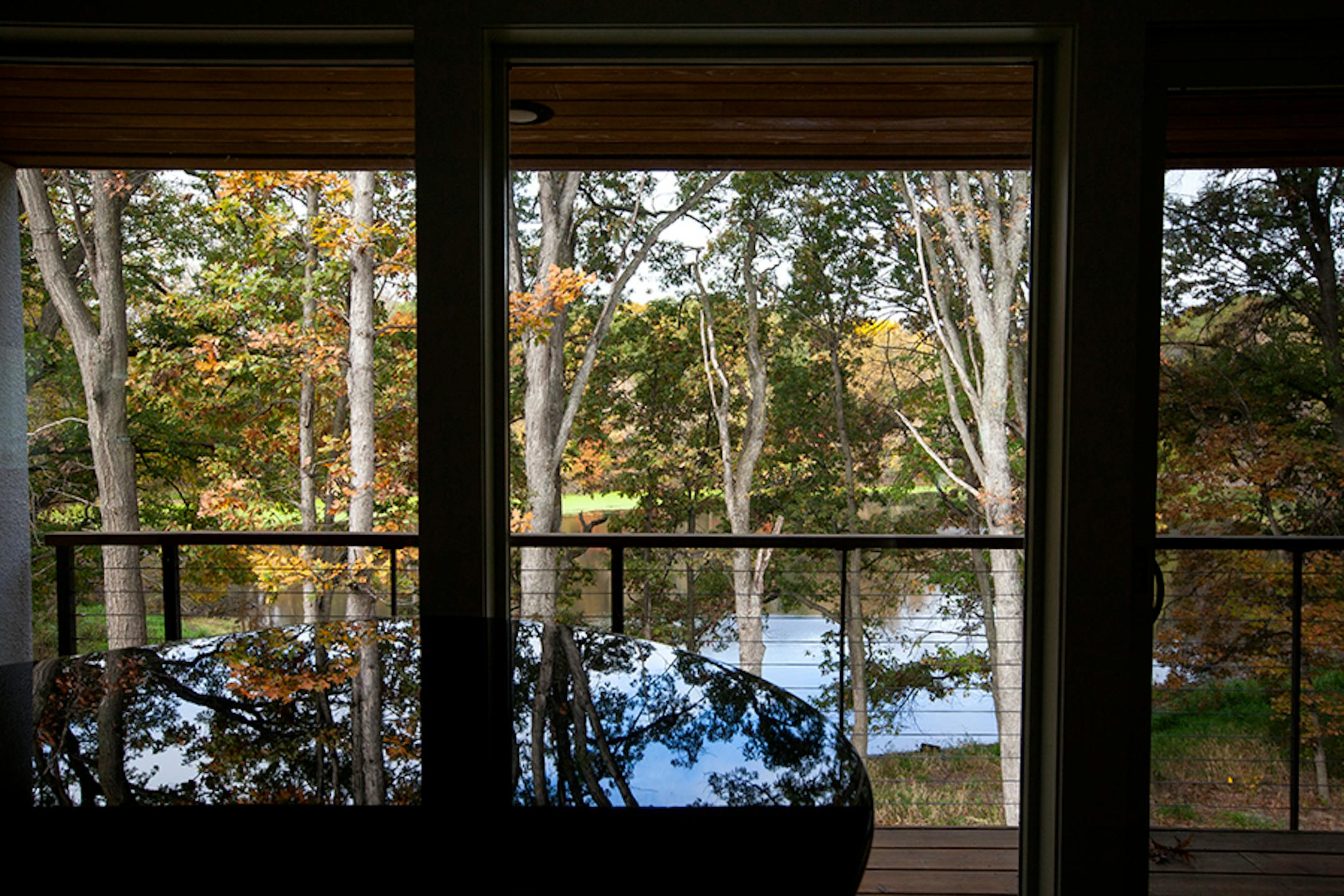 A deck with a steel cable railing overlooking the pond is off the living room.