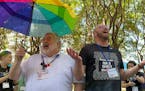 The Rev. David Meredith, left, and the Rev. Austin Adkinson sing during a gathering of those in the LGBTQ community and their allies outside the Charl