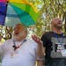 The Rev. David Meredith, left, and the Rev. Austin Adkinson sing during a gathering of those in the LGBTQ community and their allies outside the Charl