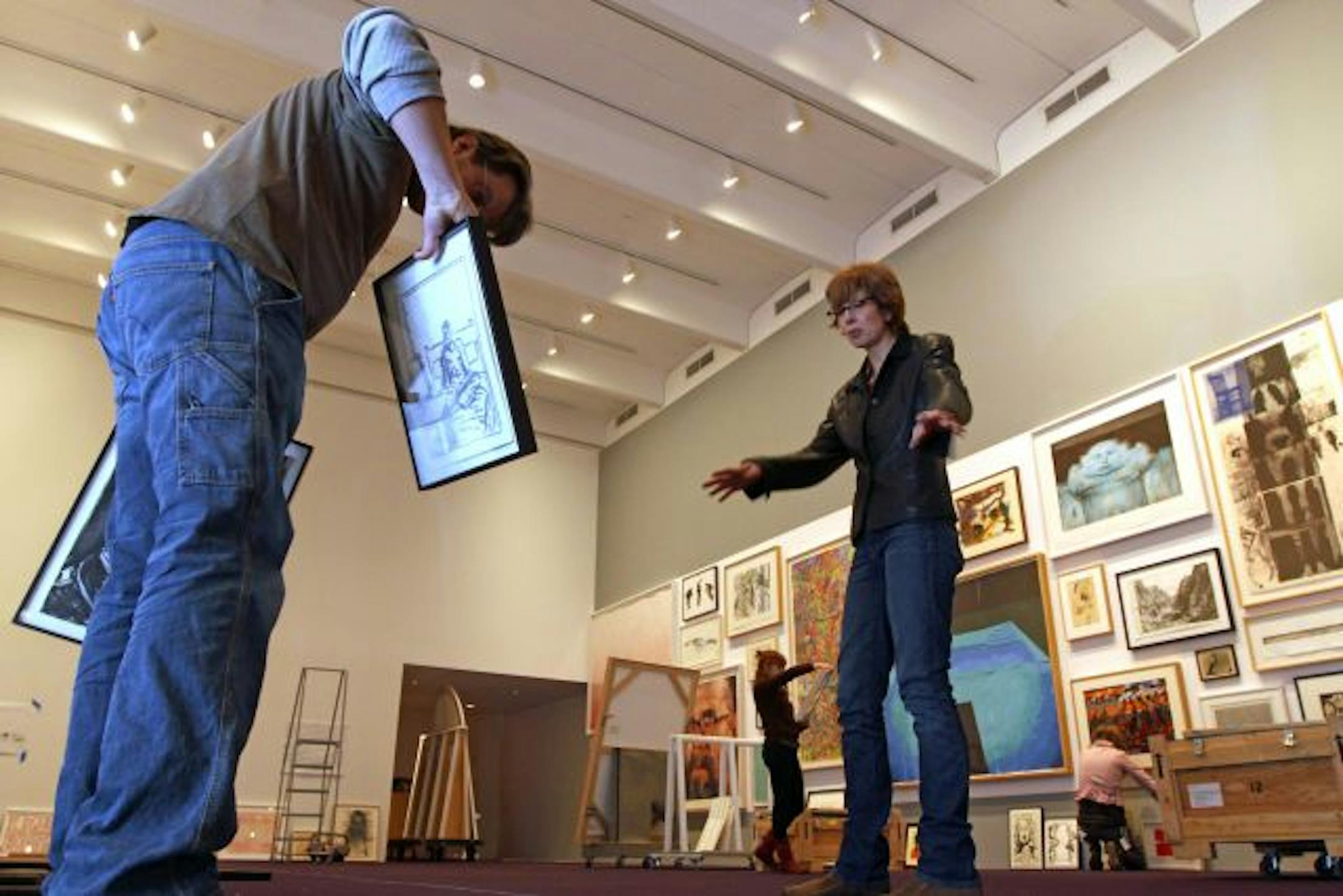 Doc Czypinski held up works as Walker curator Darsie Alexander arranged them for the "50/50" exhibit.