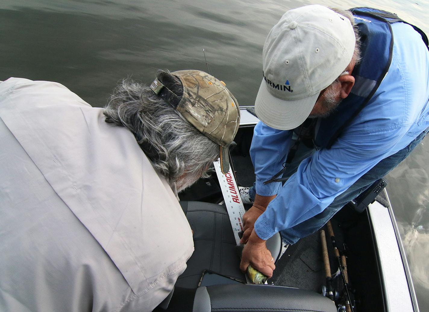 Don Pereira, left, and Scott Hennessey measure the bluegill Scott caught last weekend on Lake Pepin as part of an in-house tournament for members of the Waterdogs Fishing Club.