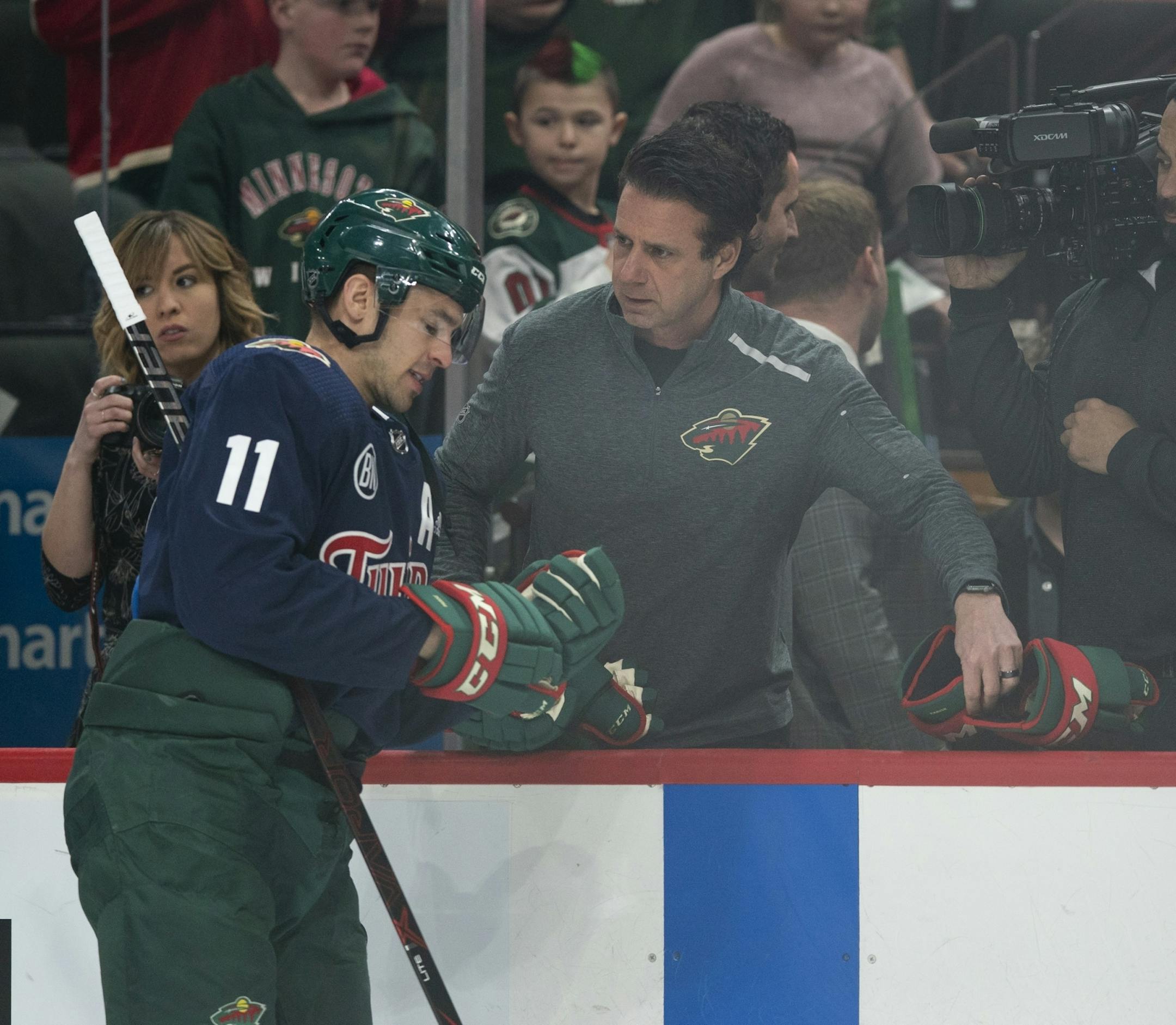 The Wild's Head Equipment Manager Tony Dacosta swapped out a pair of gloves with left wing Zach Parise (11) during pregame warmups Tuesday night.