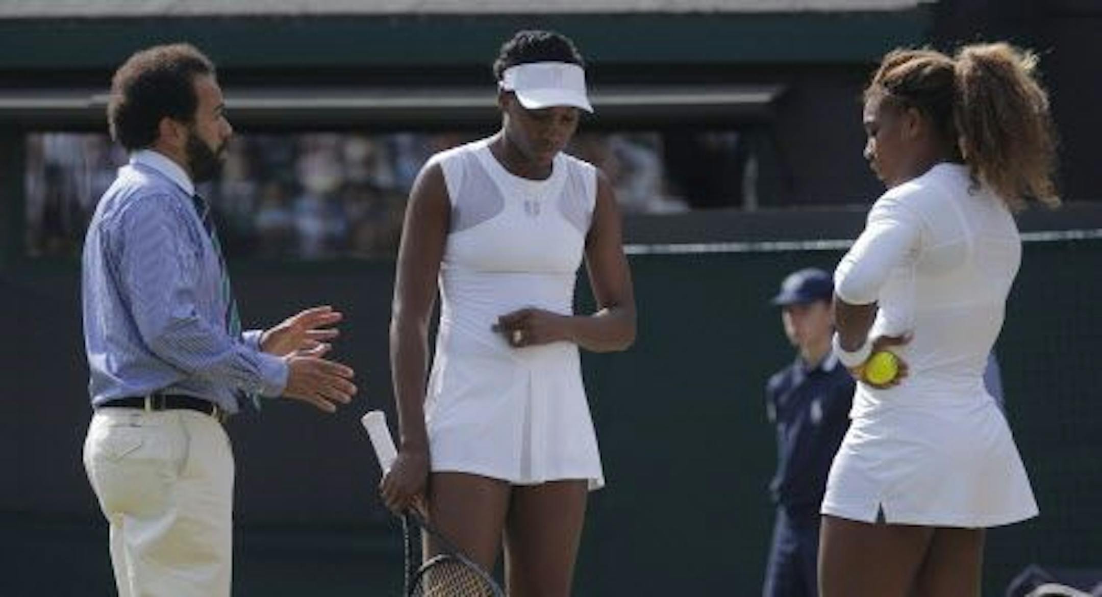 Umpire Kader Nouni talks to Serena Williams, right, and Venus Williams of the U.S during their women's doubles match against Kristina Barrios of Germany and Stefanie Voegele of Switzerland at the All England Lawn Tennis Championships in Wimbledon, London, Tuesday July 1, 2014. The Williams sisters retired after 3 games.