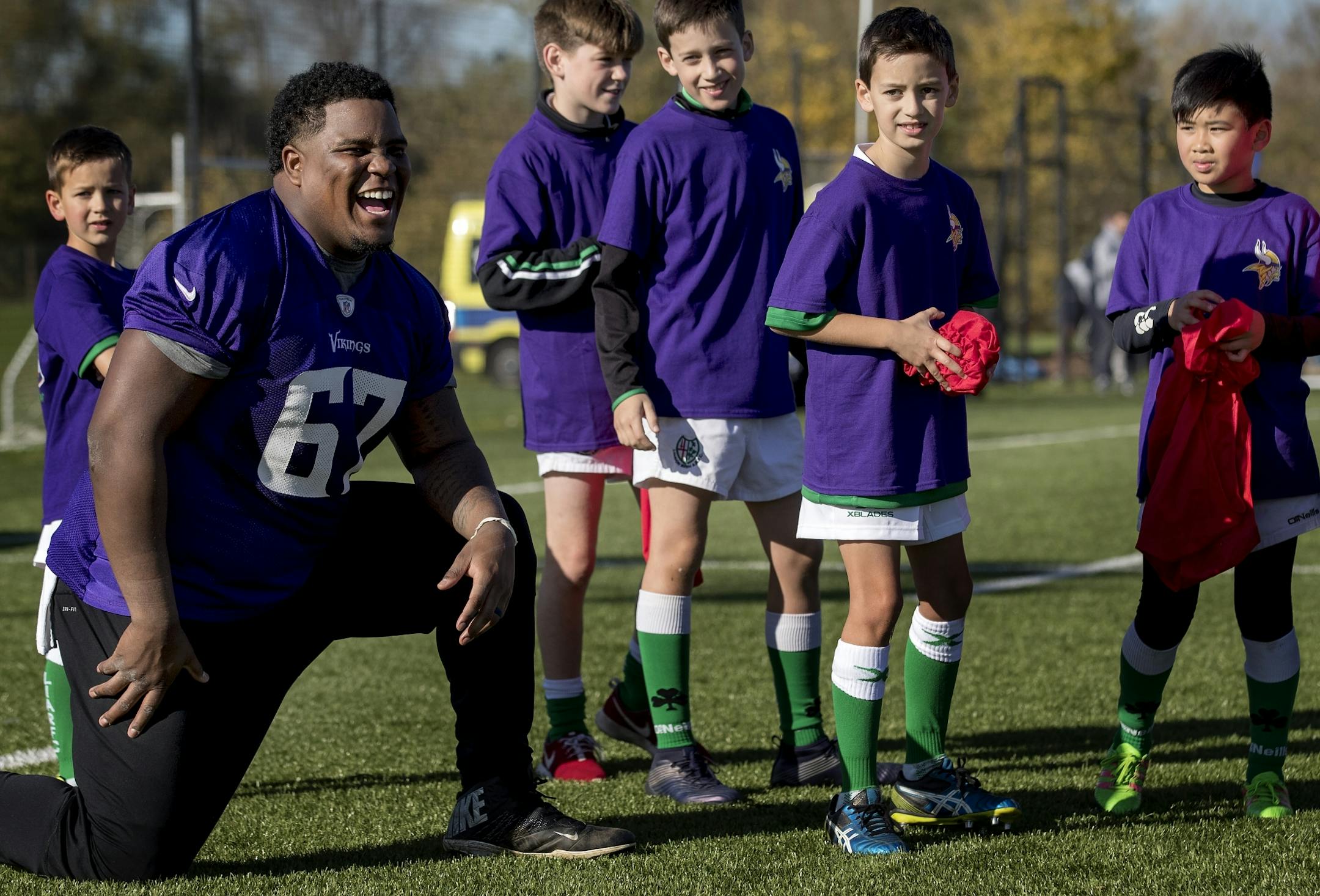 Cornelius Edison (67) worked with young athletes during an NFL FLAG event after Minnesota Vikings practice at the London Irish Training Ground.