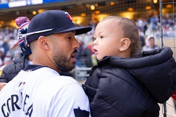 Twins shortstop Carlos Correa holds his two sons, Kylo and Kenzo, left to right, before Thursday's home opener against the Guardians at Target Field.