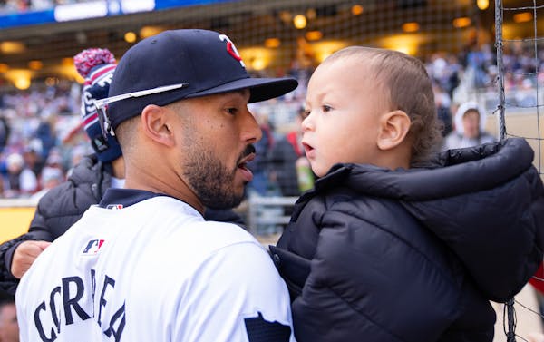 Twins shortstop Carlos Correa holds his two sons, Kylo and Kenzo, left to right, before Thursday's home opener against the Guardians at Target Field.
