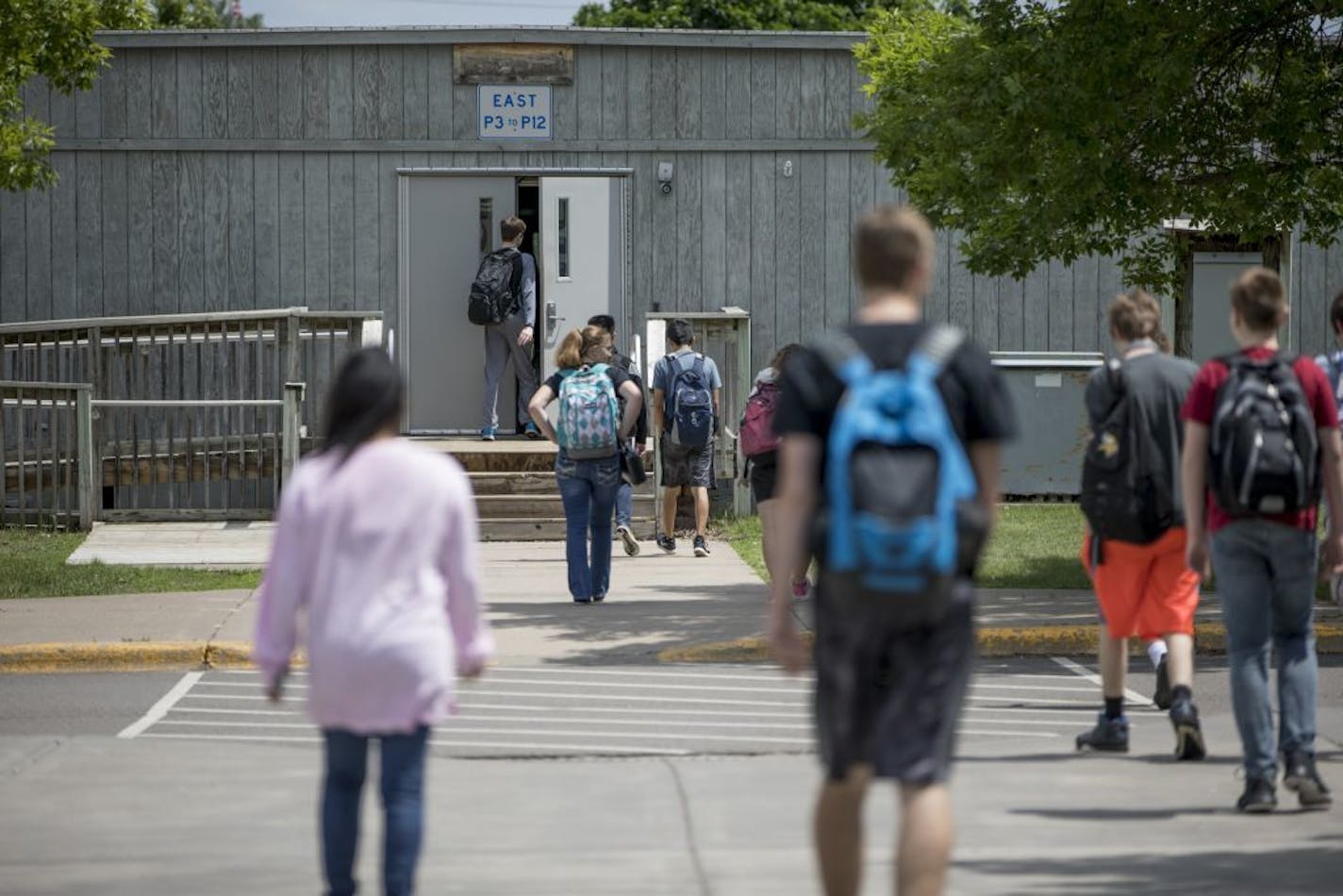 Students walked between the portable classrooms and the main school building between the bell at Champlin High School on May 31, 2018, in Champlin, Minn. Voters last fall approved the largest school referendum in Minnesota history in the Anoka-Hennepin School District, backing a $249 million plan that will makeover or add on to every single one of the district's 38 buildings that includes eliminated these portable classrooms.