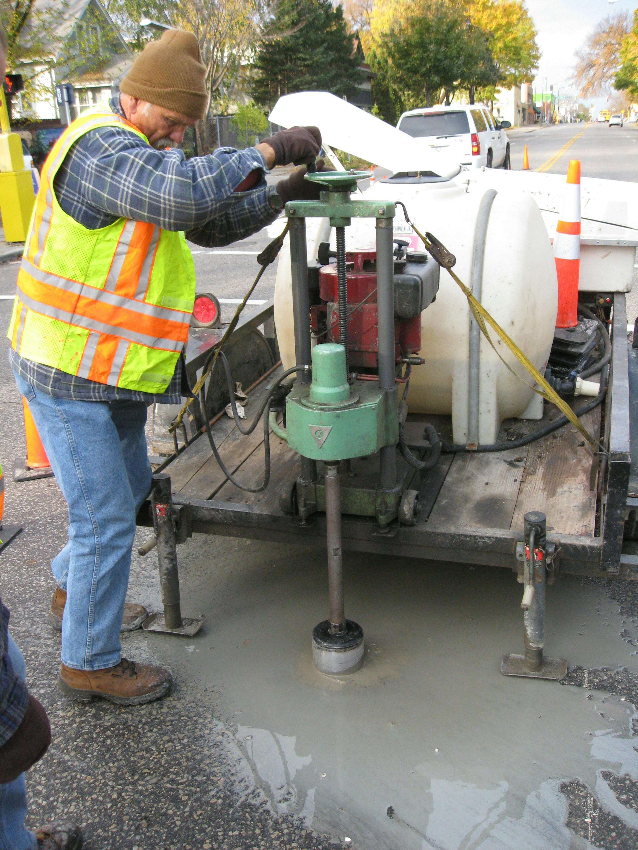 Steve Brandt .. 10.23.2008 ... Hennepin County survey worker Lowell Schraeder drills out a site for a survey marker on Franklin Avenue in Minneapolis.