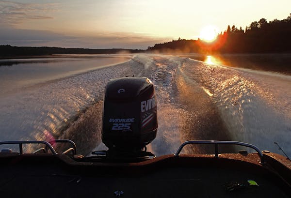 As the sun rose over the treetops lining Lake of the Woods, a boat carrying anglers to favorite fishing spots carved a picturesque wake.
