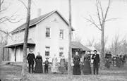 Andrew and Elsa Peterson and their nine children in front of their farmhouse near Waconia, likely in the 1890s.