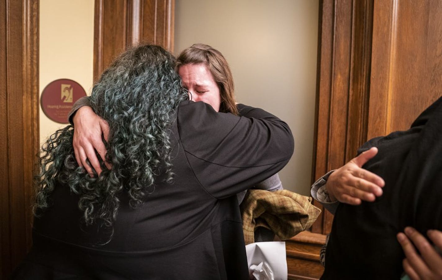 Sexual assault survivor Sarah Super of Break the Silence hugs Rep. Aisha Gomez (DFL-Minneapolis) after testifying about eliminating the statute of limitations for criminal sexual assault cases during the meeting.