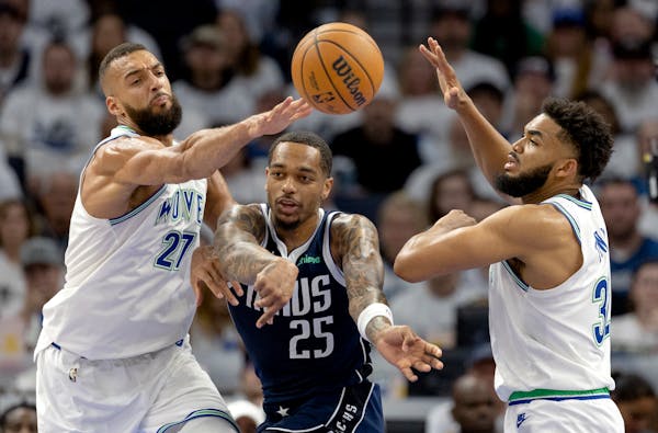 P.J. Washington (25) of the Mavericks is defended by Rudy Gobert (27) and Karl Anthony Towns of the Wolves on Wednesday night at Target Center.