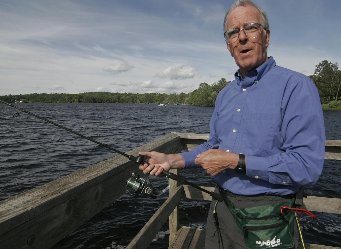 Photo by Doug Smith/Star Tribune; June 12, 2014; Dr. Roland Kehr shows how his M-POW-R motorized reel works. A push button on the rod (near his right thumb) activates the motor, which is powered by a battery pack attached to Keh'r waist. A controller adjusts the speed of the retrieve. Kehr developed the device to help disabled anglers fish. "It works,'' he said.