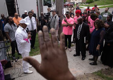 Pastor Jerry McAfee, left, helps lead a prayer vigil for Minneapolis Police Officer Jamal Mitchell on Sunday near where Mitchell was shot and killed, 