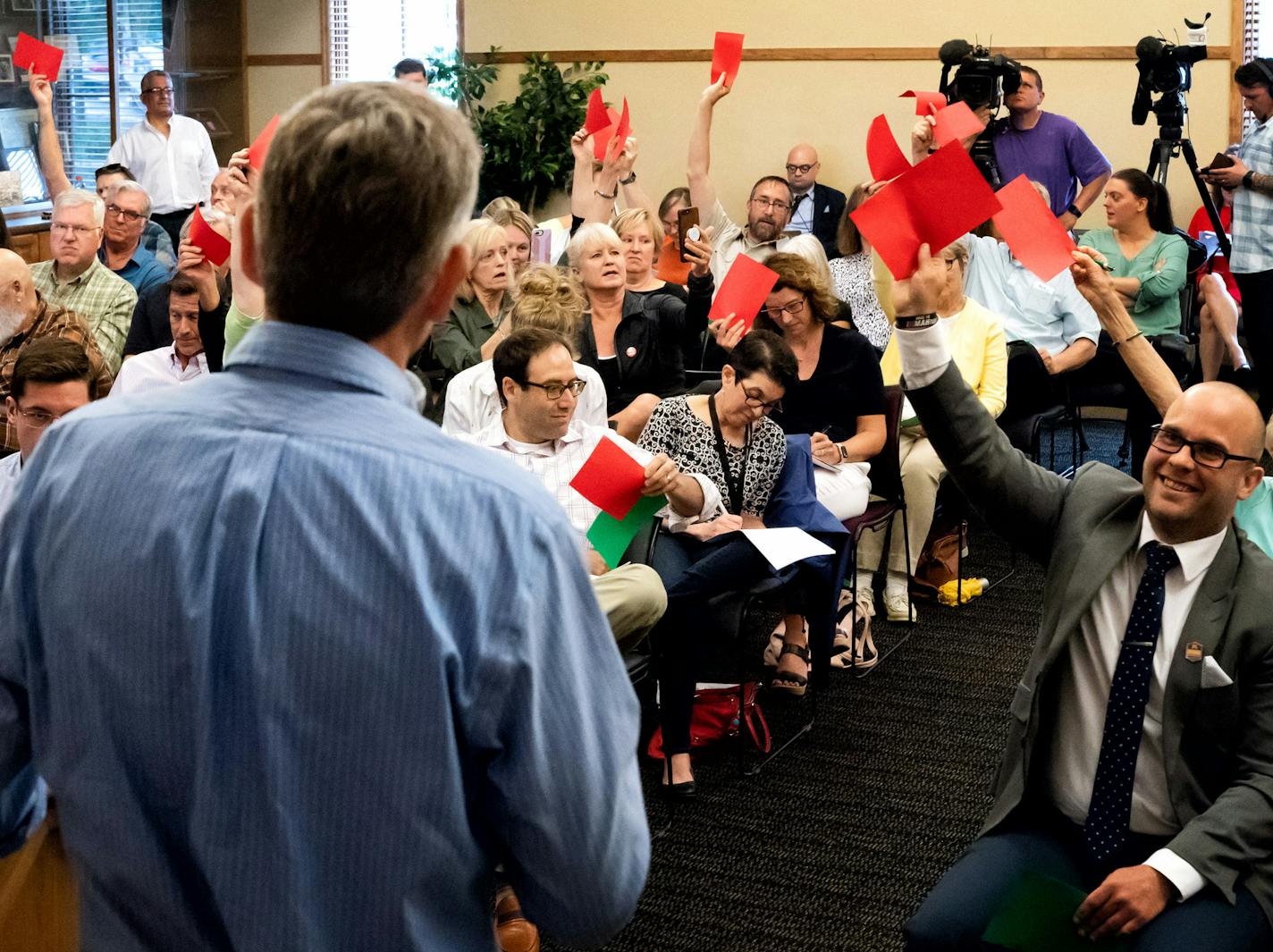 Participants at a town hall meeting Wednesday held up red "disagree cards" when U.S. Rep. Erik Paulsen refused to say that health care was a right, saying instead that access to care was a right.