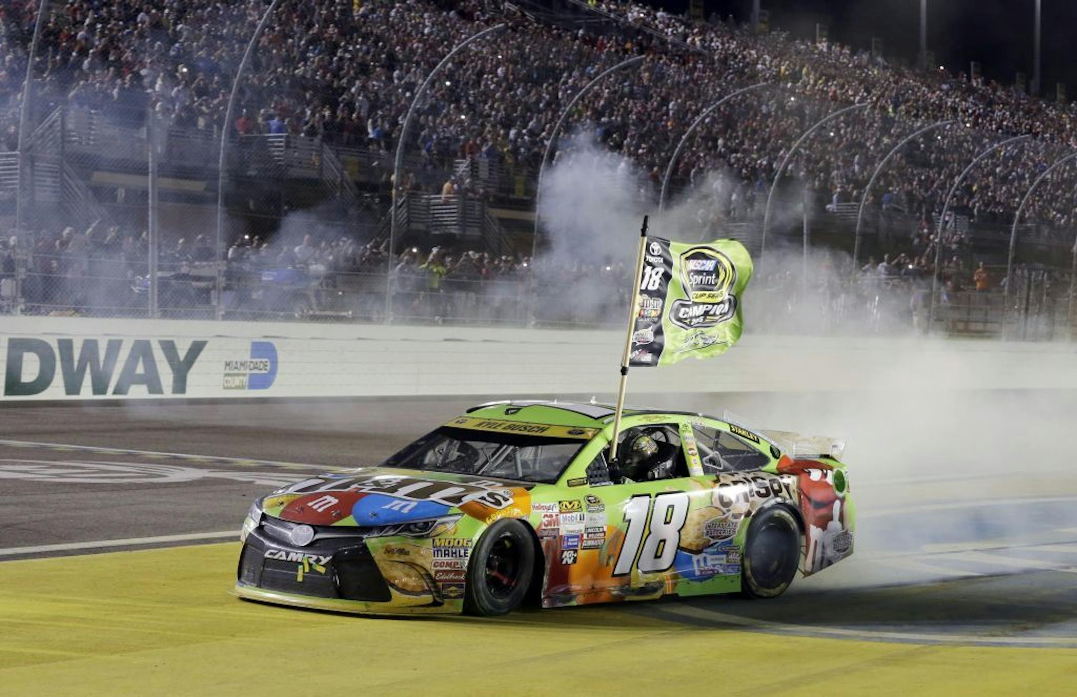 Kyle Busch celebrates after winning the NASCAR Sprint Cup Series auto race and the season title, Sunday, Nov. 22, 2015, at Homestead-Miami Speedway in Homestead, Fla.