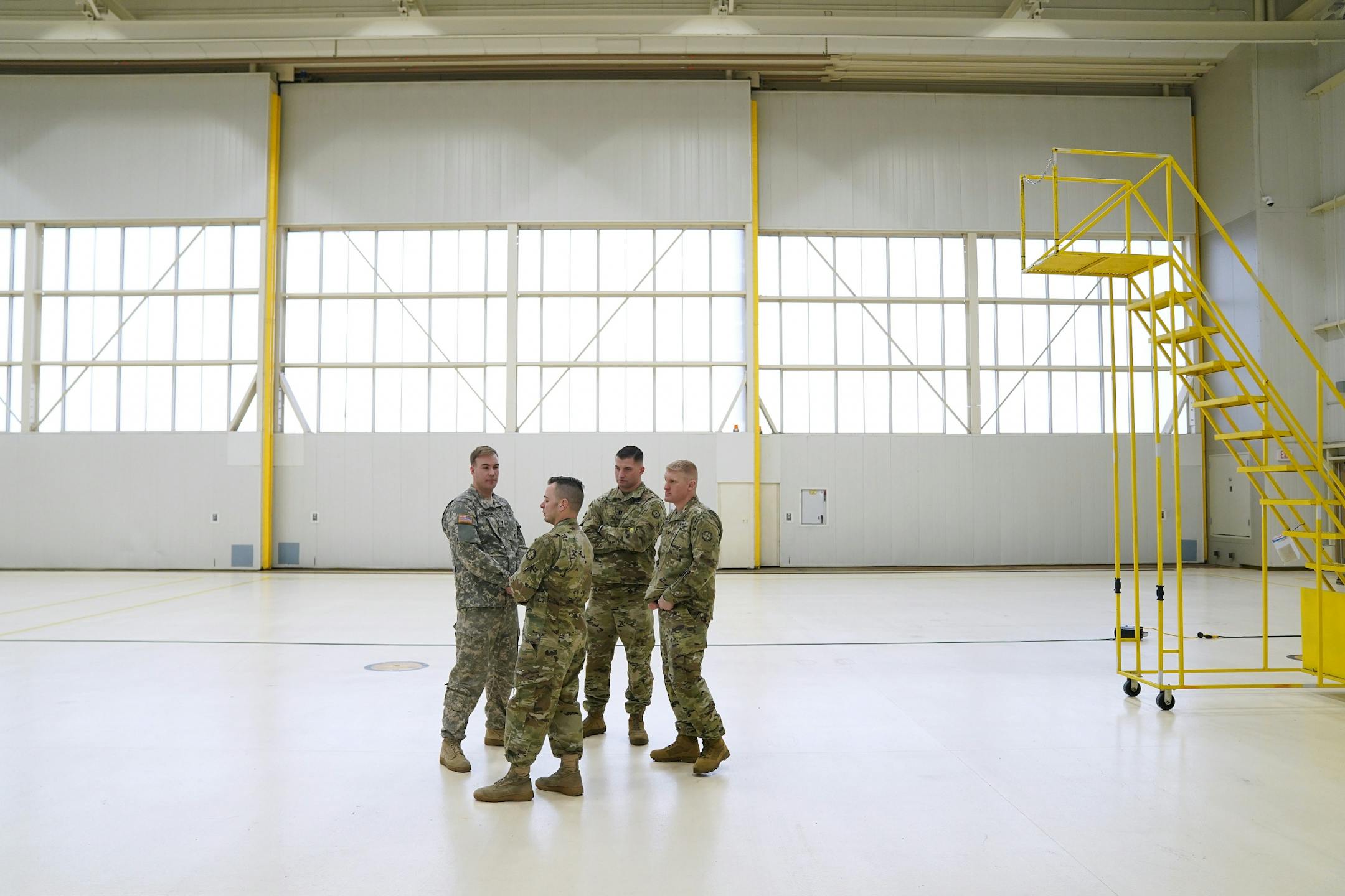 National Guard members stood in the empty hanger space where the downed UH-60 Black Hawk helicopter would have normally sat.