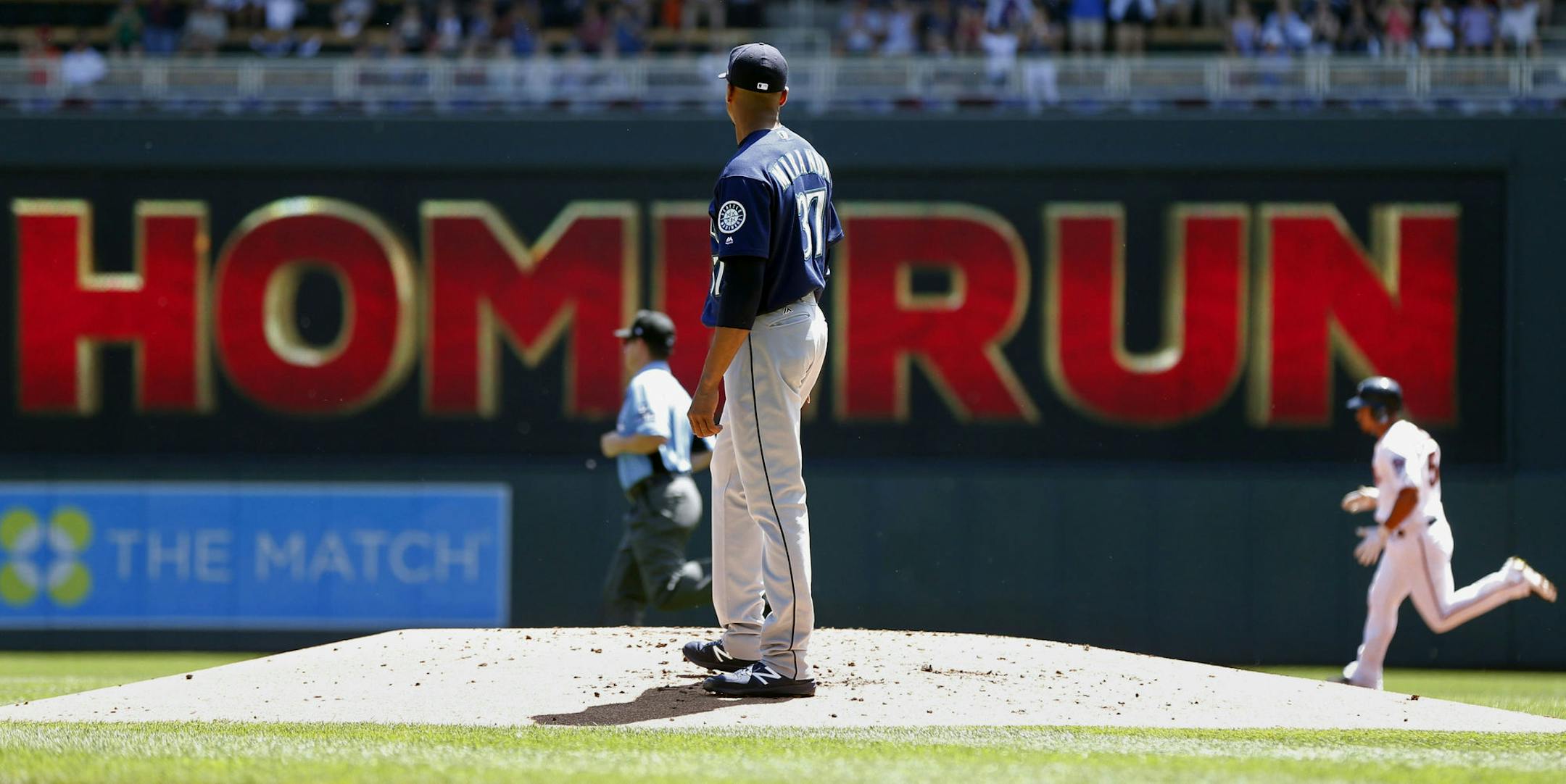 Seattle Mariners pitcher Ariel Miranda looks back after he gave up a two-run home run to Minnesota Twins' Eduardo Escobar, right, in the first inning of a baseball game Thursday, June 15, 2017, in Minneapolis. (AP Photo/Jim Mone)