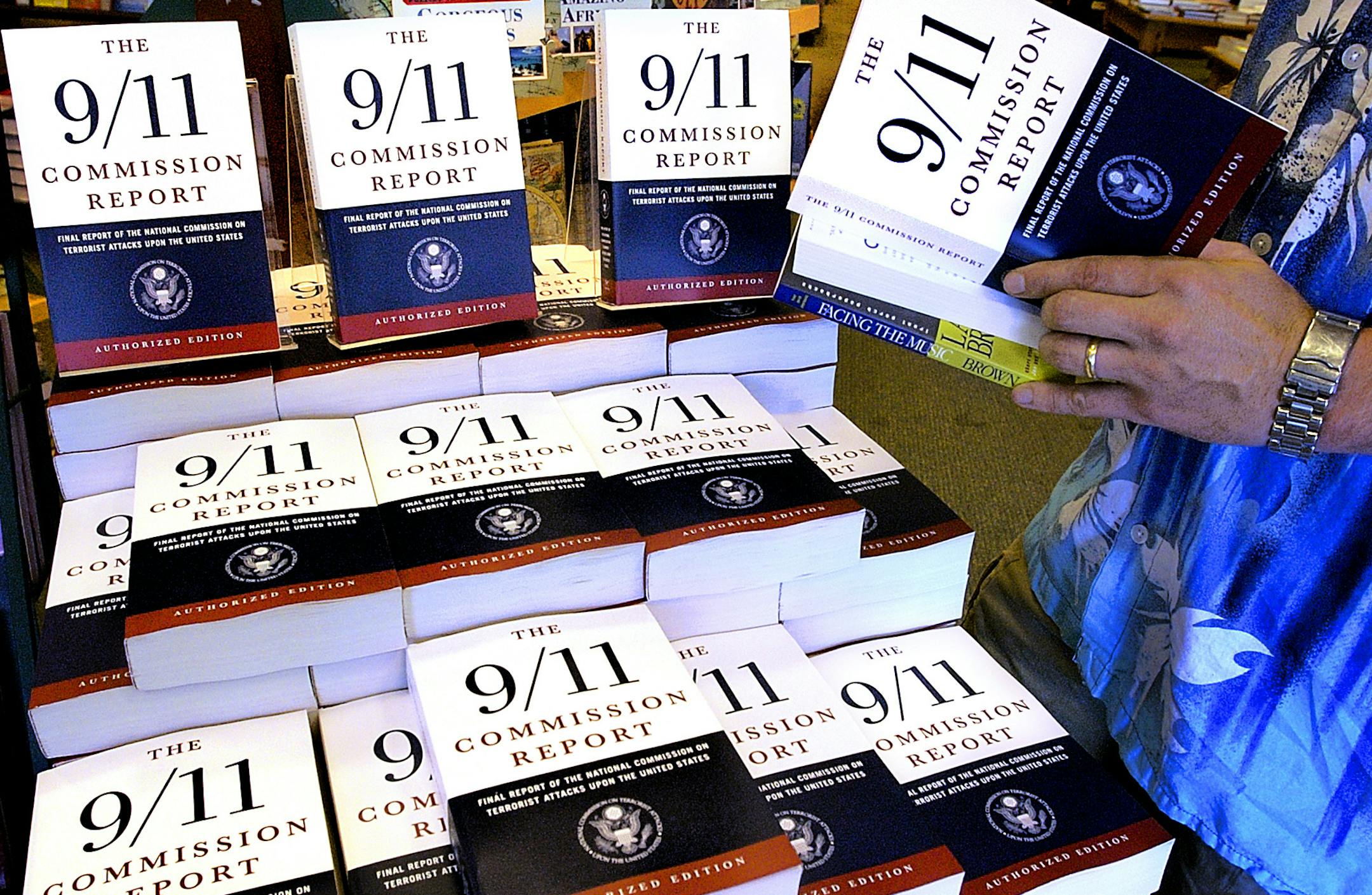 A patron of the Barnes & Noble bookstore in Springfield, Ill., reads a copy of the "The 9/11 Commission Report" Thursday, July 22, 2004. The United States government could not protect its citizens from the Sept. 11 terrorist attacks because it failed to appreciate the threat posed by al-Qaida operatives who exploited those lapses to carry out the deadliest assault ever on American soil, the chairman of the Sept. 11 commission Tom Kean said Thursday. (AP Photo/Seth Perlman) ORG XMIT: ILSP103