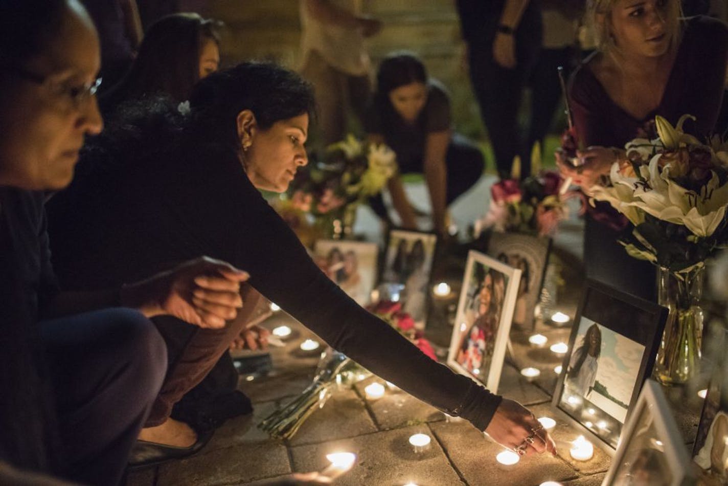 Ria Patel's mother Devyani Patel continually lit candles around her pictures during a vigil for Ria at St. Thomas University on Thursday, September 21, 2017, in St. Paul, Minn.