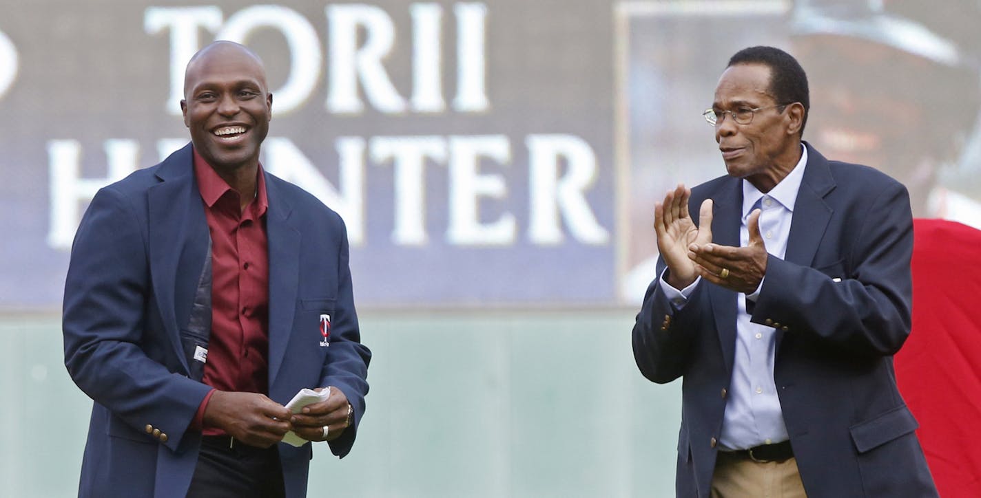 Former Minnesota Twin Rod Carew, right, applauds former outfielder Torii Hunter after Carew presented Hunter his jacket after Hunter's induction into the Twins Hall of Fame on Saturday, July 16, 2016, in Minneapolis. (AP Photo/Jim Mone)