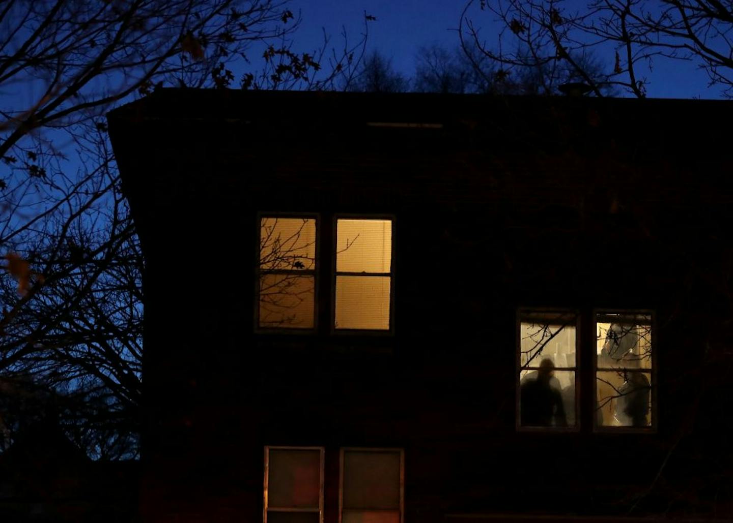 Police were called to a scene in St. Paul during the early morning hours where a woman was found unresponsive and later died. Here, police investigators are seen in an upstairs hallway window Wednesday, Feb. 26, 2020, in St. Paul, MN.