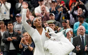 Serena Williams waves as she leaves the court after losing to France's Harmony Tan in a first round women's singles match on day two of Wimbledon