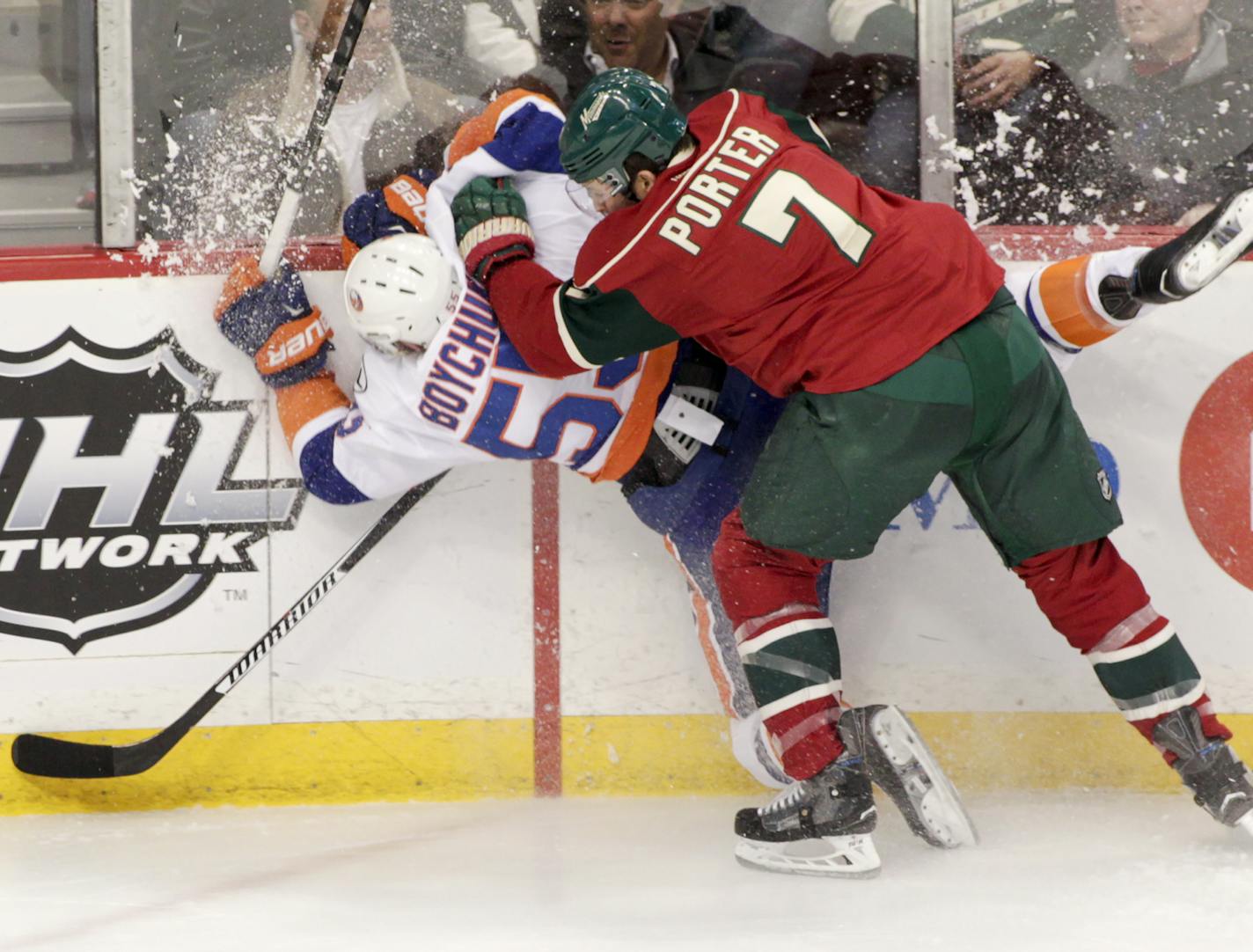 New York Islanders defenseman Johnny Boychuk (55) is checked into the boards by Minnesota Wild left wing Chris Porter (7) during the first period of an NHL hockey game, Tuesday, Feb. 23, 2016, in St. Paul, Minn. (AP Photo/Paul Battaglia)