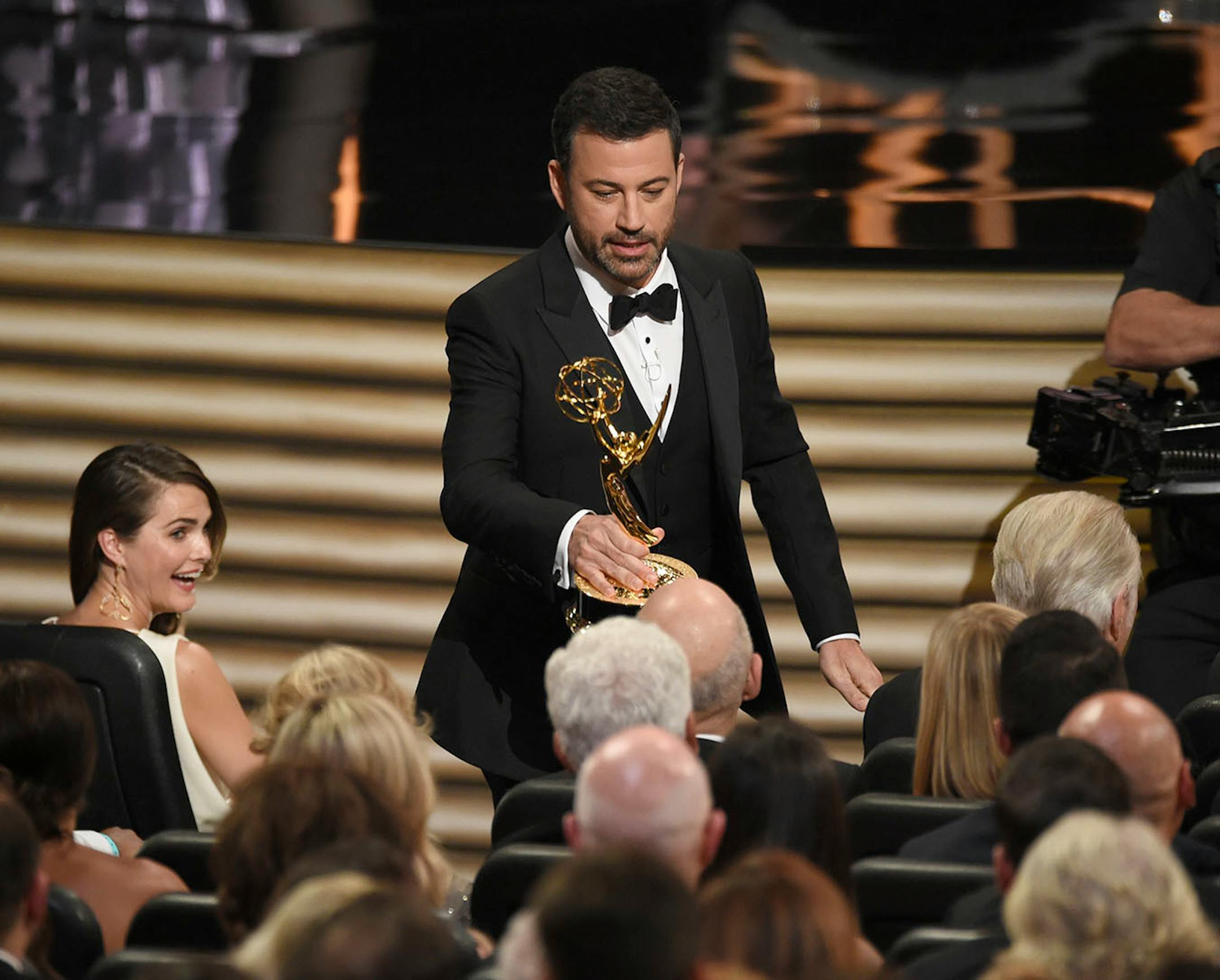 Host Jimmy Kimmel hands an Emmy award to Jeffrey Tambor during the opening of the 68th Primetime Emmy Awards on Sunday, Sept. 18, 2016, at the Microsoft Theater in Los Angeles. (Photo by Chris Pizzello/Invision/AP)