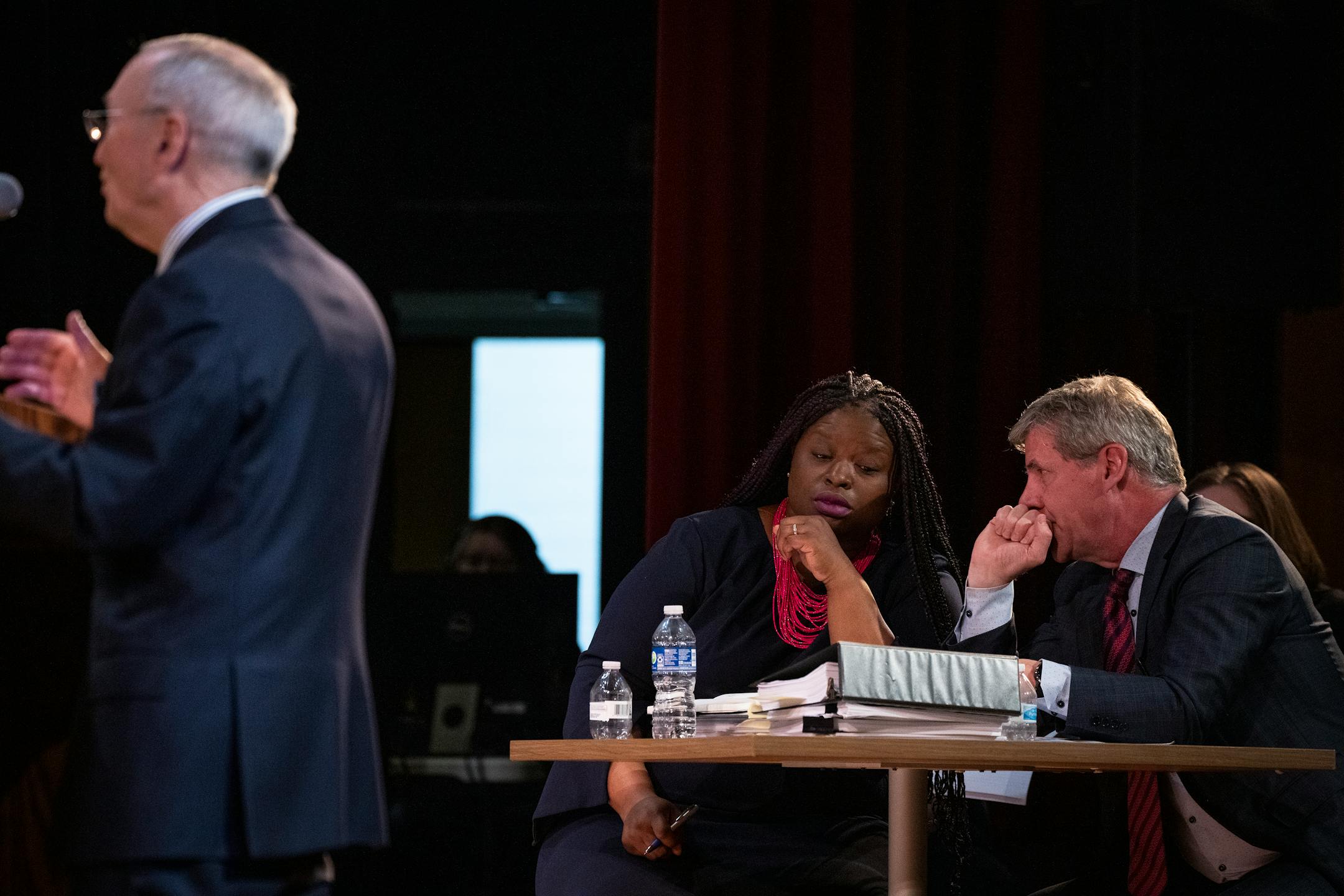 Attorneys representing the intervenor-respondent, Nekima Levy Armstrong, left, and Jack Perry confer as the Minnesota Supreme Court hears oral arguments in the case Cruz-Guzman v. State of Minnesota inside the auditorium at Richfield High School.