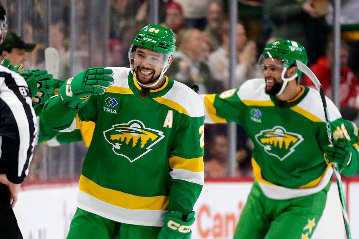 Minnesota Wild defenseman Matt Dumba (24) is congratulated after scoring a goal while Minnesota Wild left wing Jordan Greenway, right, skates in during the second period of an NHL hockey game against the Detroit Red Wings, Wednesday, Dec. 14, 2022, in St. Paul, Minn. (AP Photo/Andy Clayton-King)