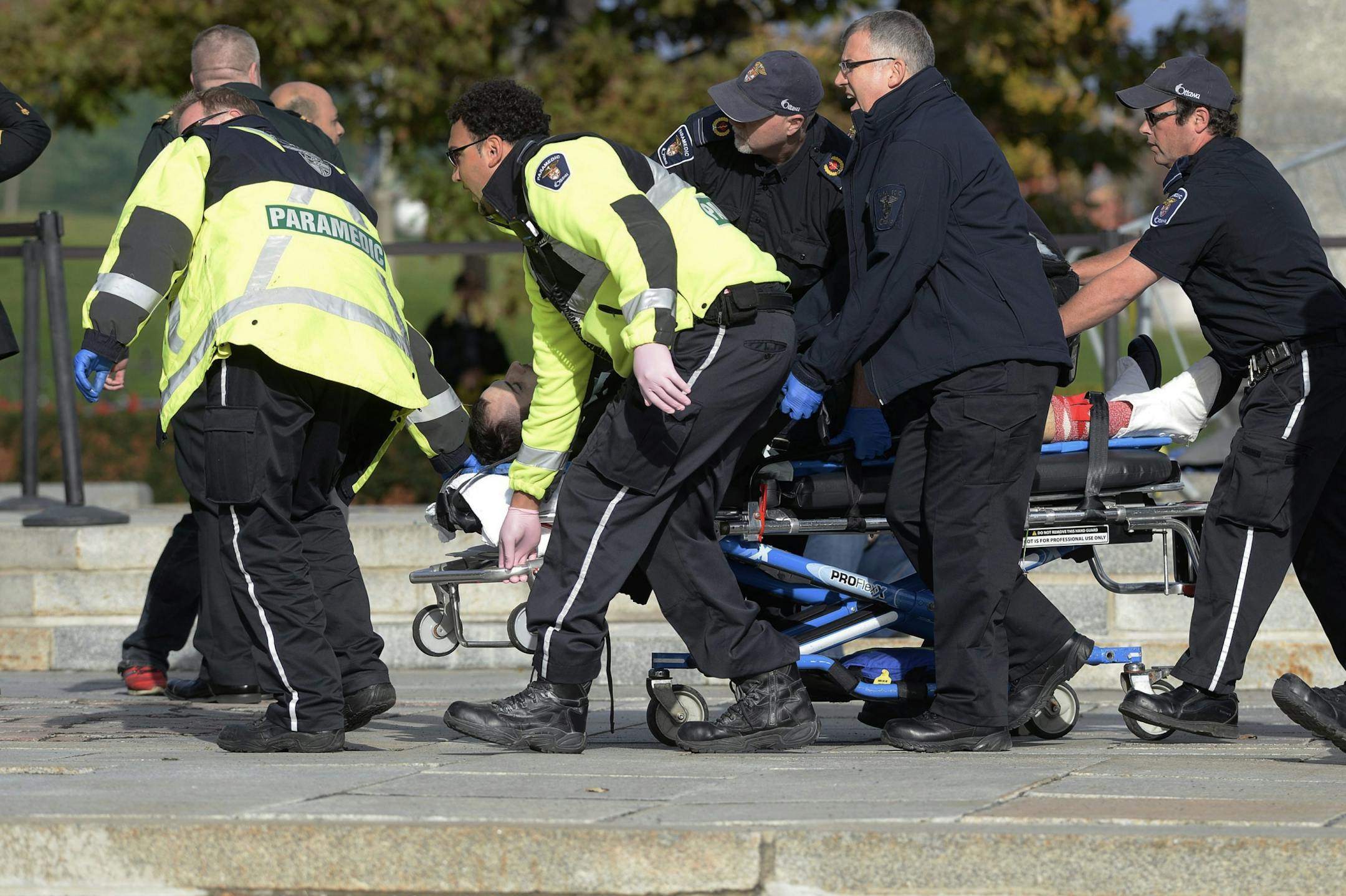 Paramedics and police pull a victim away from the Canadian War Memorial in Ottawa on Wednesday Oct. 22, 2014. A soldier standing guard at the National War Memorial in Ottawa has been shot by an unknown gunman and people report hearing gunfire inside the halls of Parliament. The gunman reportedly ran towards Parliament Hill, which is currently under lockdown and surrounded by security. Prime Minister Stephen Harper was rushed away from the building to an undisclosed location, officials in his off