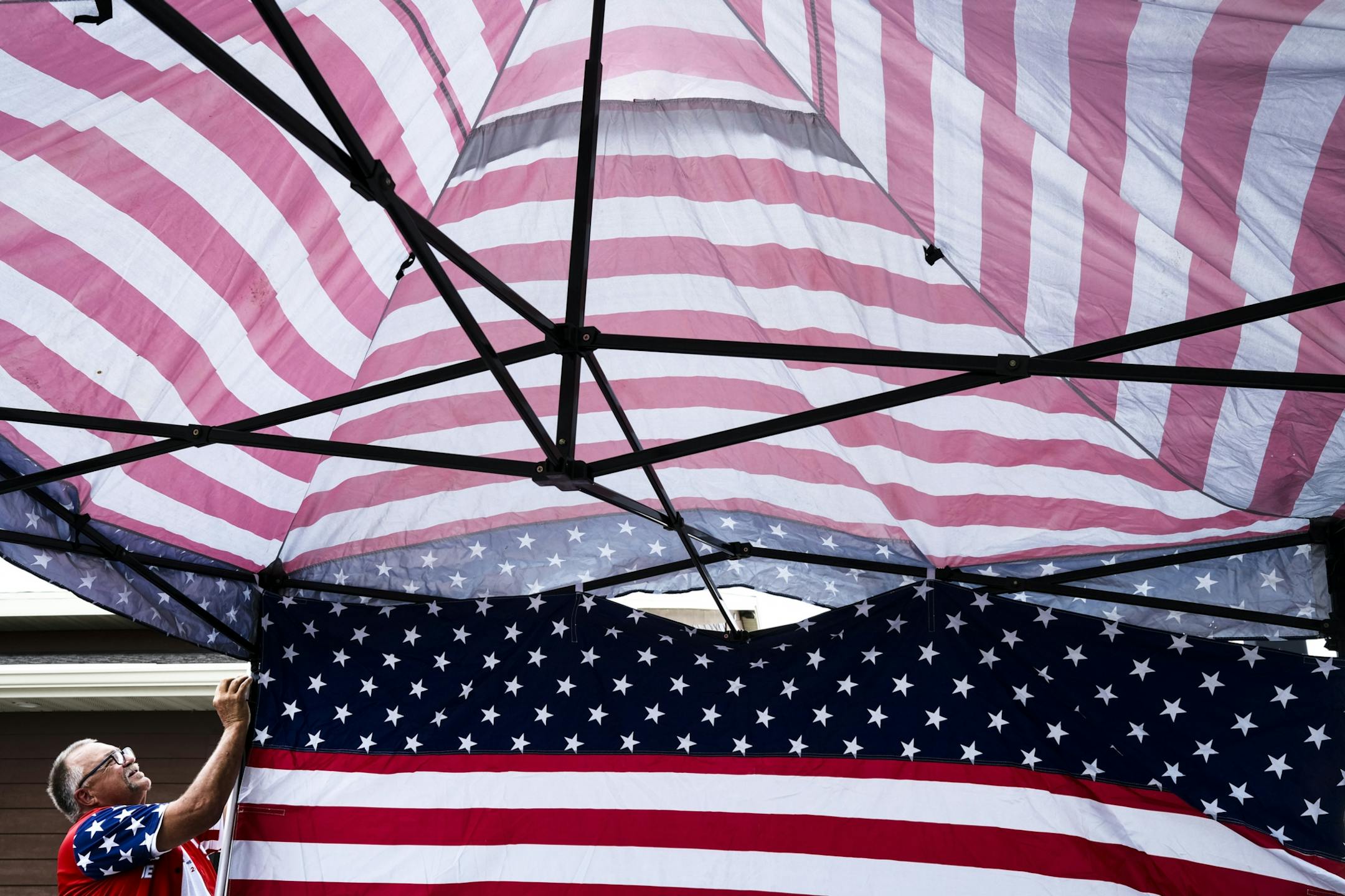 Trump supporter Randal Thom, a dog breeder from Lakefield, Minn., set up a tent made up of US and Trump flags outside Max's Grill and Sheep Shedde Inn in Olivia, Minn.