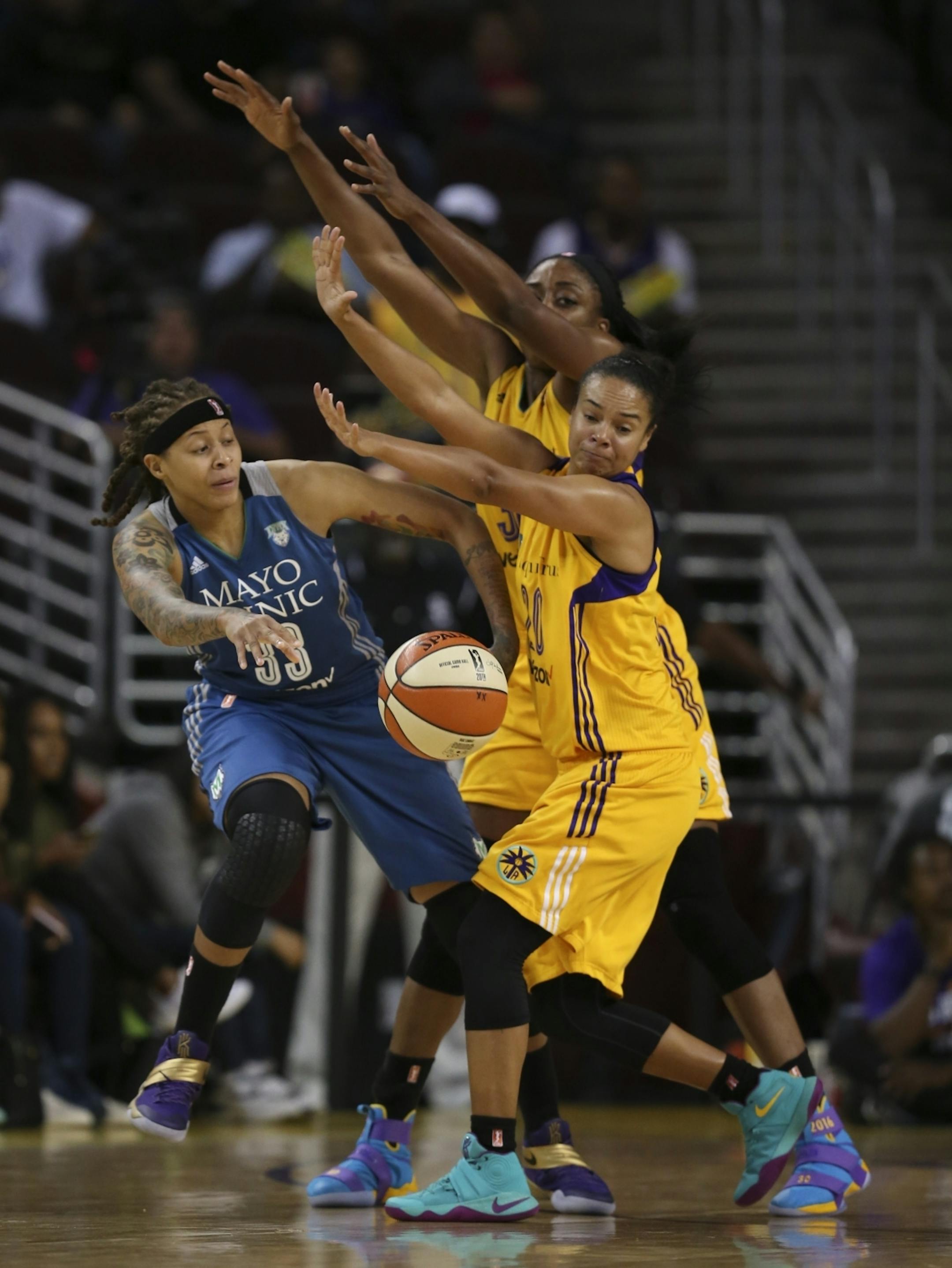 Minnesota Lynx guard Seimone Augustus (33) got rid of the ball under the aggressive defense of Los Angeles Sparks forward Nneka Ogwumike (30) and Sparks guard Kristi Toliver (20) in the second half.