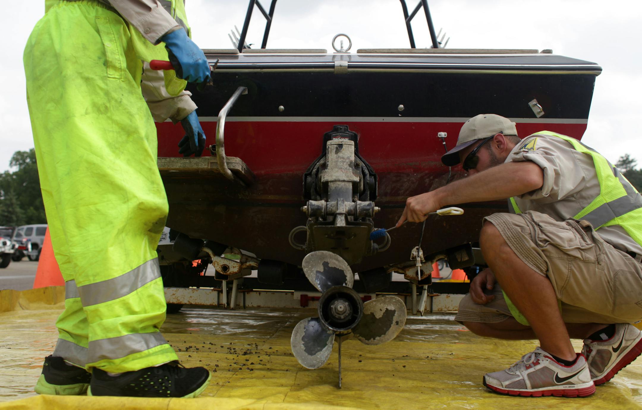 Joe Hale and Ben Troop, DNR Watercraft Inspectors, scrub dead zebra mussels off a boat that had been fined $300 for not following aquatic invasive species laws, at Gray's Bay boat ramp on Thursday afternoon.] The Minnesota Department of Natural Resources is ramping up enforcement of aquatic invasive species. MONICA HERNDON monica.herndon@startribune.com Minnetonka, MN 07/10/14 ORG XMIT: MIN1407101738460906