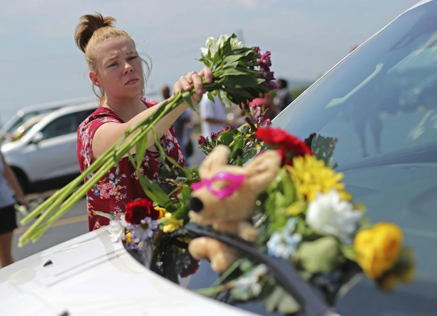 Jasmine Burkhardt leaves flowers on a car believed to belong to a victim of a last night's duck boat accident, Friday, July 20, 2018 in Branson, Mo. The country-and-western tourist town of Branson, Missouri, mourned Friday for more than a dozen sightseers who were killed when a duck boat capsized and sank in stormy weather in the deadliest such accident in almost two decades.