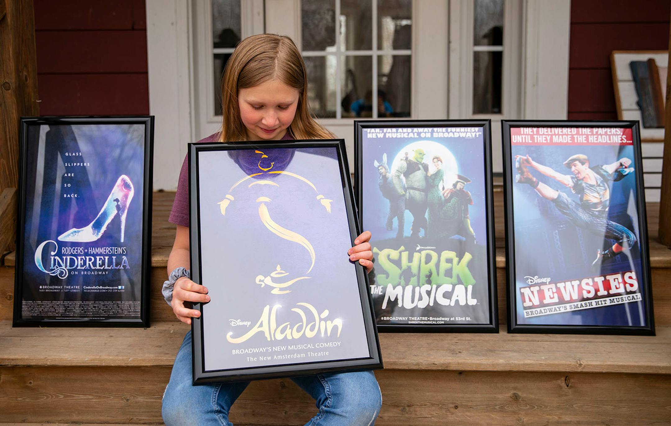 Elsie Sather, 9, posed for a portrait with some of her favorite musical posters in Cloquet. When asked about the pandemic Sather said, "It makes me sad, a little bit grateful because no one in my family got sick with the coronavirus [...] I listen to songs from these musicals and they make me happy".