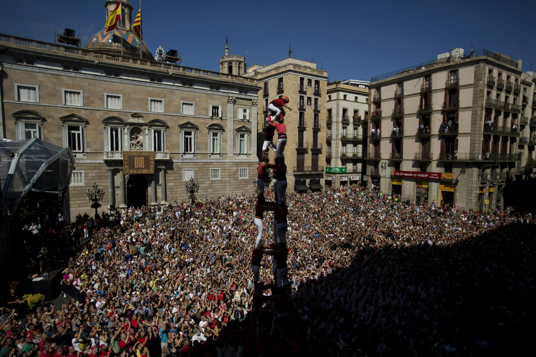Members of the Castellers Joves Xiquets de Valls form a human tower or "Castellers" during the Saint Merce celebrations in San Jaime square in Barcelona, Spain, Sunday, Sept. 20, 2015. The tradition of building human towers or “castells” dates back to the 18th century and takes place during festivals in Catalonia, where “colles” or teams compete to build the tallest and most complicated towers. A “castell” is considered completely successful when it is l
