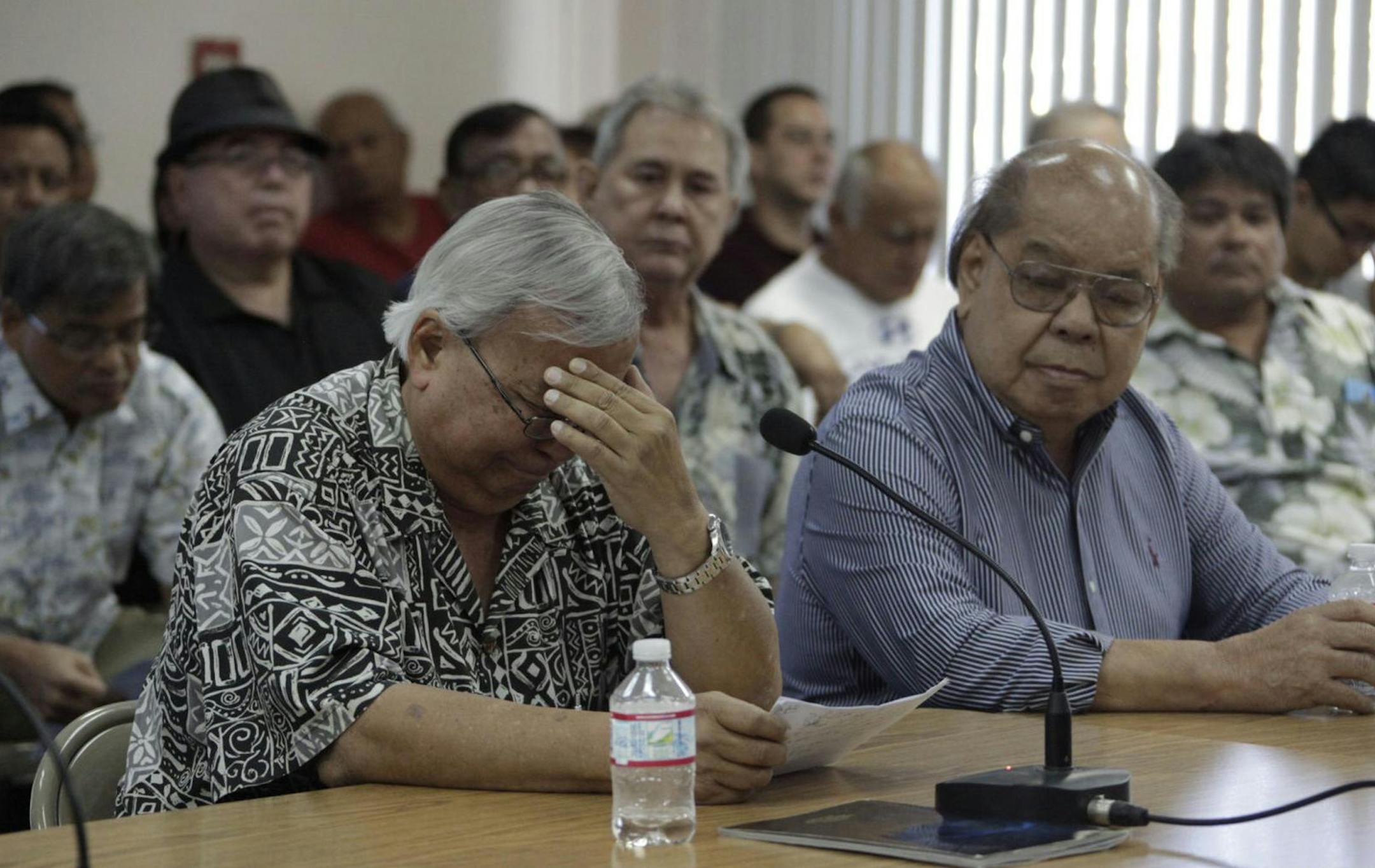 Leo Tudela, left, chokes away tears while Anthony San Nicolas offers support. Tudela described how he had been sexually molested by Catholic clergy when he was an altar server in the 1950s. He testified in favor of Bill 326-33 during a public hearing at the Guam Legislature in Hag&#xe5;t&#xf1;a, Monday, Aug. 1. Matt Weiss/Post
