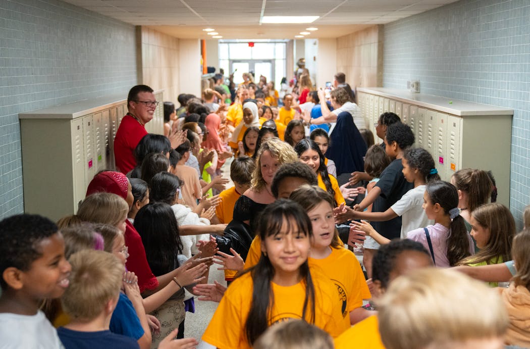 Graduating fourth-grade students gave high-fives to younger students on the last day of school at Hayes Elementary School in Fridley in June.