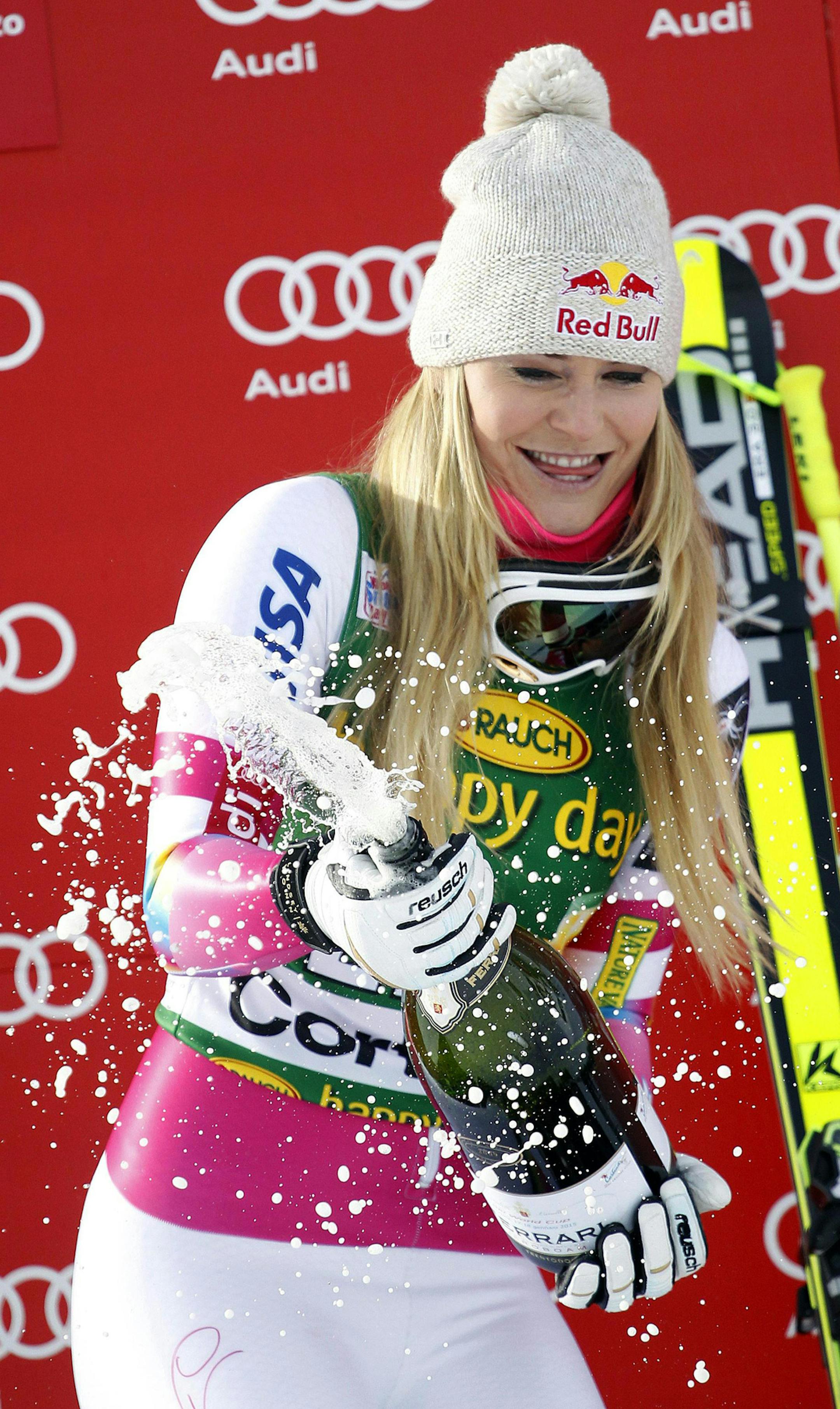 Lindsey Vonn celebrates on the podium after winning an alpine ski, women's World Cup super-G, in Cortina d'Ampezzo, Italy, Monday, Jan. 19, 2015. Lindsey Vonn won a super-G Monday for her record 63rd World Cup victory and celebrated with an embrace from a surprise visitor, boyfriend Tiger Woods. The American broke Annemarie Moser-Proell's 35-year-old record of 62 World Cup wins with a flawless run down the Olympia delle Tofane course, finishing 0.85 ahead of Anna Fenninger of Austria. (AP Photo/