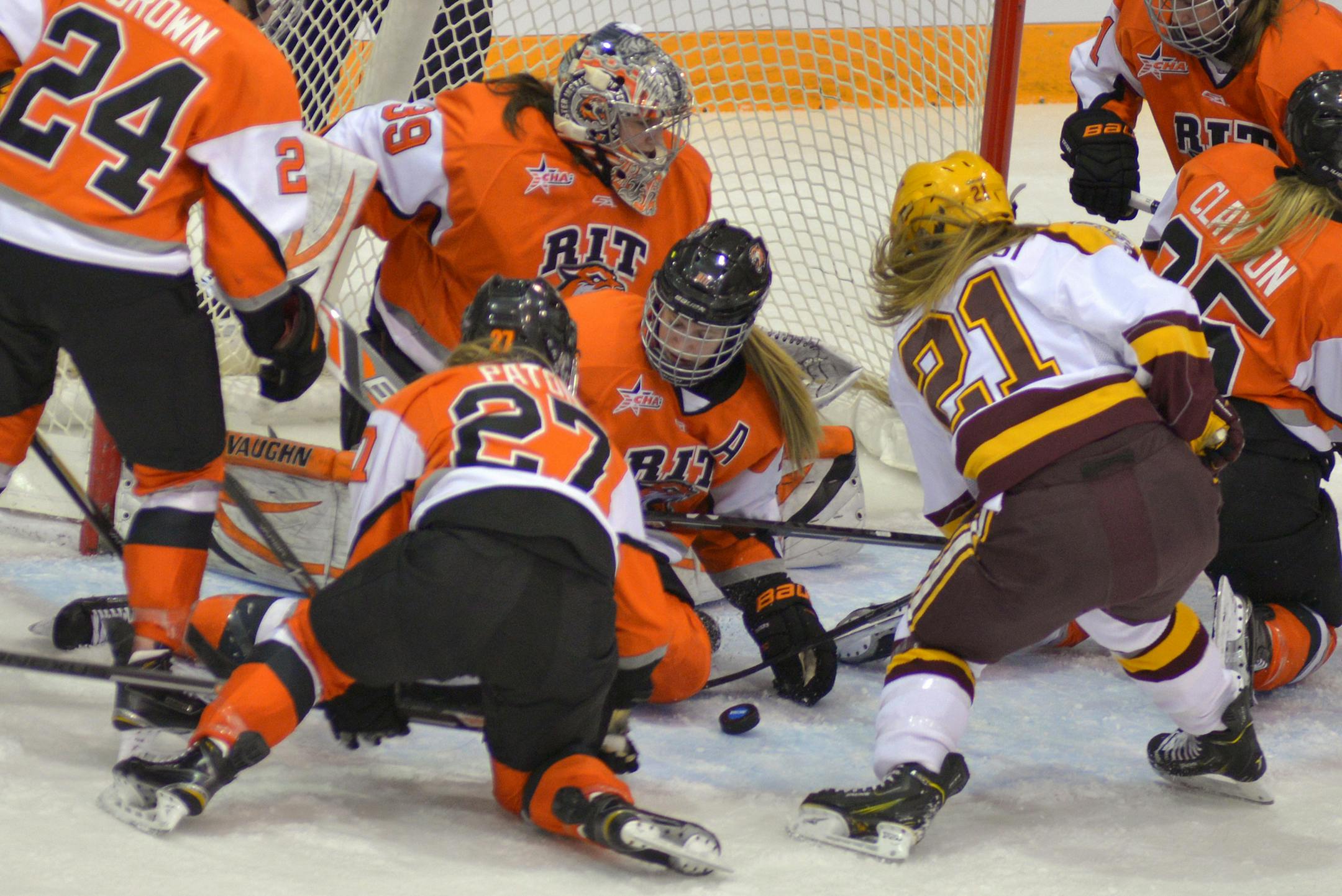 Minnesota sophomore right wing Dani Cameranesi attempts a shot with commotion in front of RIT goaltender Ali Binnington during the second period of the NCAA quarterfinal game Saturday, March 14 at the University of Minnesota's Ridder Arena. Minnesota led RIT, 5-1 at the end of the period. ] (SPECIAL TO THE STAR TRIBUNE/BRE McGEE) **Dani Cameranesi (MN, 21), Ali Binnington (RIT, goaltender)