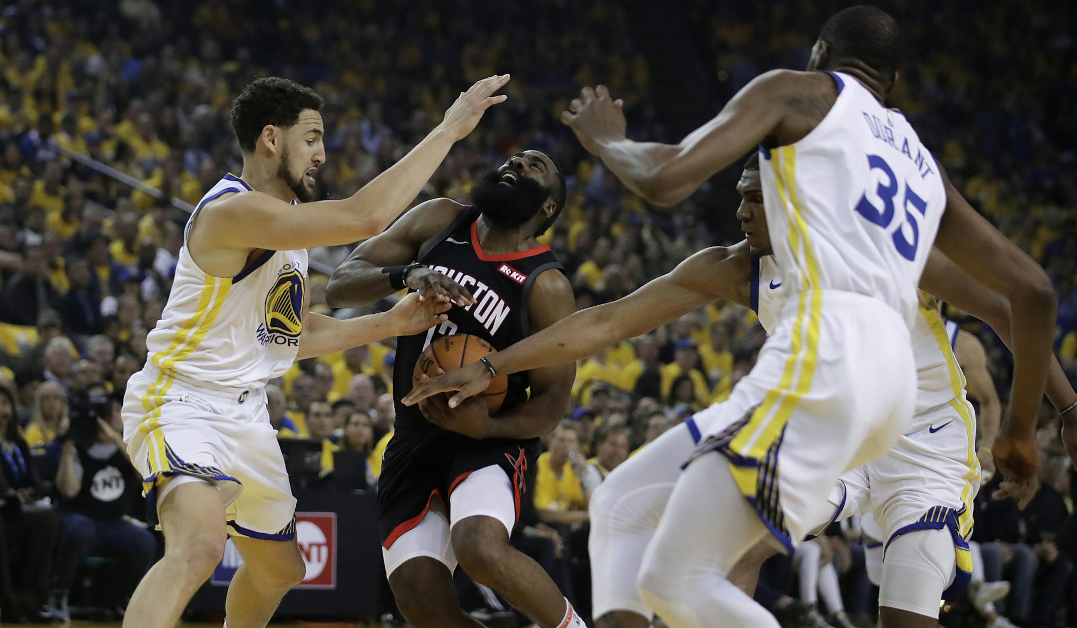 Houston Rockets' James Harden, second from left, drives the ball against Golden State Warriors' Klay Thompson, left, Kevon Looney, and Kevin Durant, right fribtm during the first half of Game 5 of a second-round NBA basketball playoff series Wednesday, May 8, 2019, in Oakland, Calif. (AP Photo/Ben Margot)