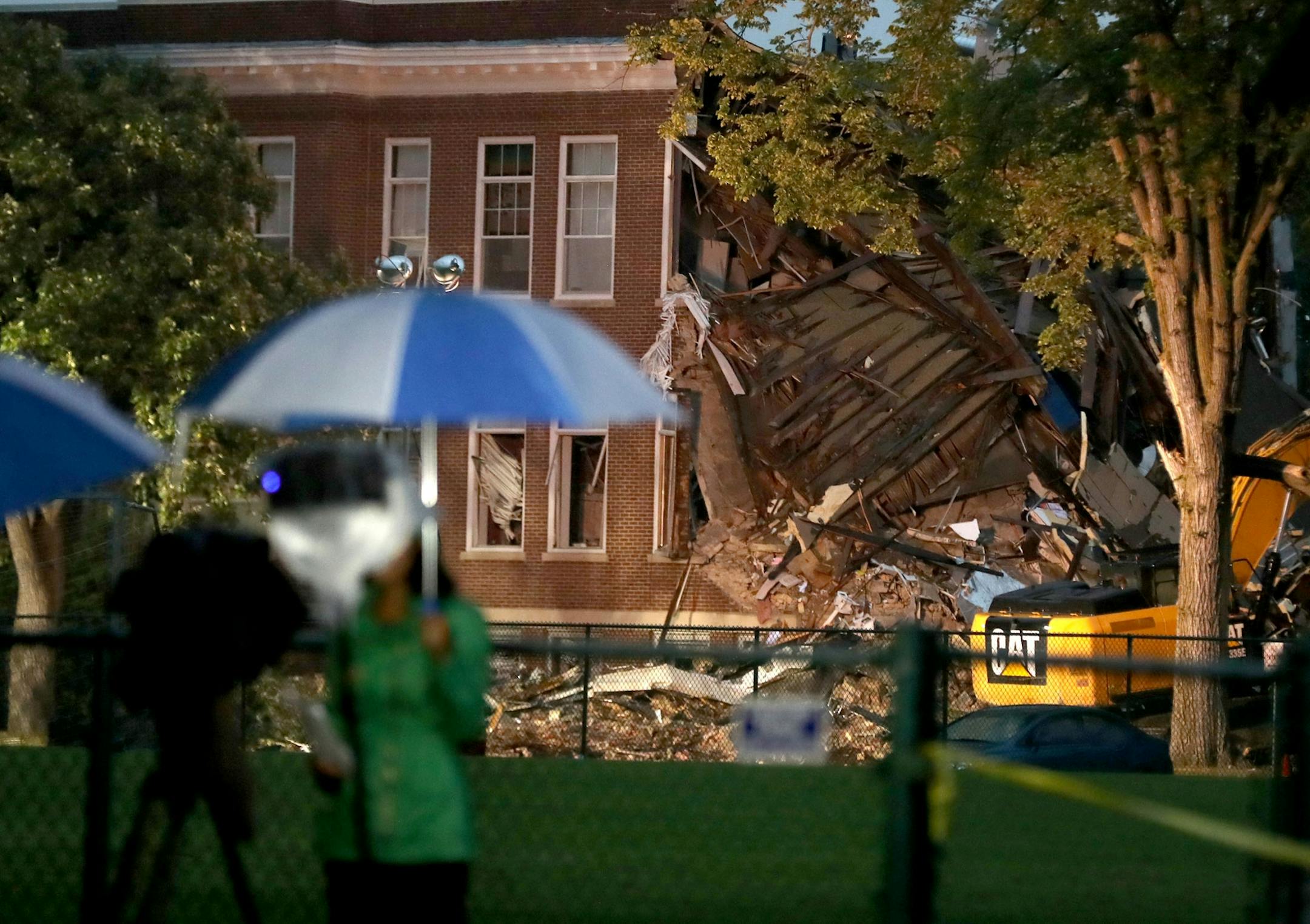 A day after an explosion and building collapse at Minnehaha Academy that left two dead and several injured, the scene was quiet as light rain fell and media members tried to stay dry Thursday, Aug. 3, 2017, in Minneapolis, MN.