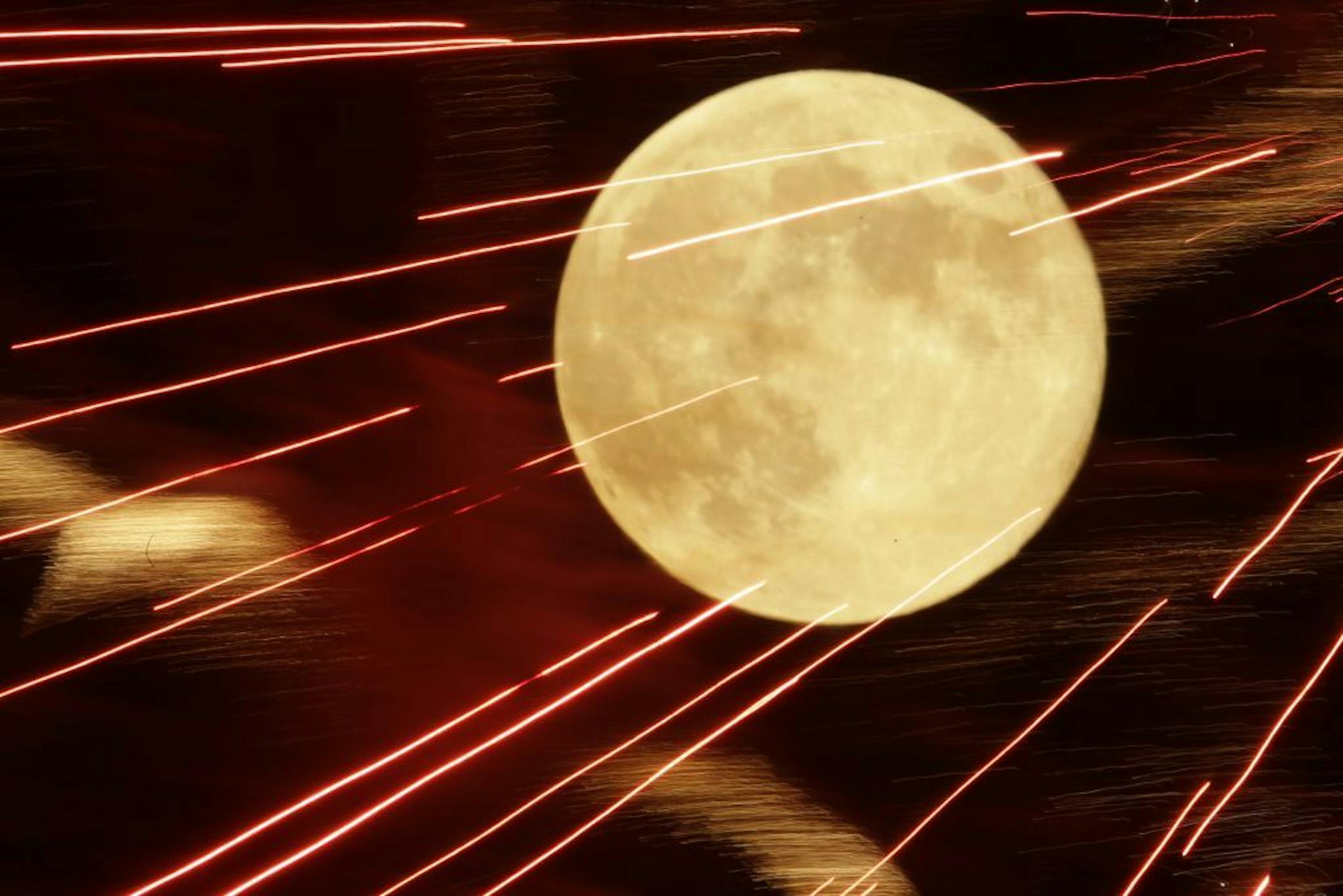 Fireworks are seen against the full moon during a Fourth of July celebration in Kansas City, Kan. Tuesday, July 3, 2012.