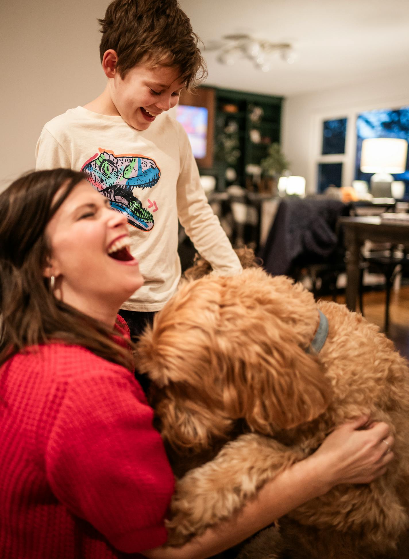 Claire Williams plays with her son Amos,9, and dog Webster who helps out with emotional support in Arden Hills, Minn., on Thursday, Nov. 2, 2023. The Williams family will be at home with their son, Amos, who is progressing with treatment of a condition called PANDAS/PANS. The condition is triggered by infections such as strep, which can result in aggressive, compulsive and even psychotic behaviors in children. ] RICHARD TSONG-TAATARII • richard.tsong-taatarii @startribune.com