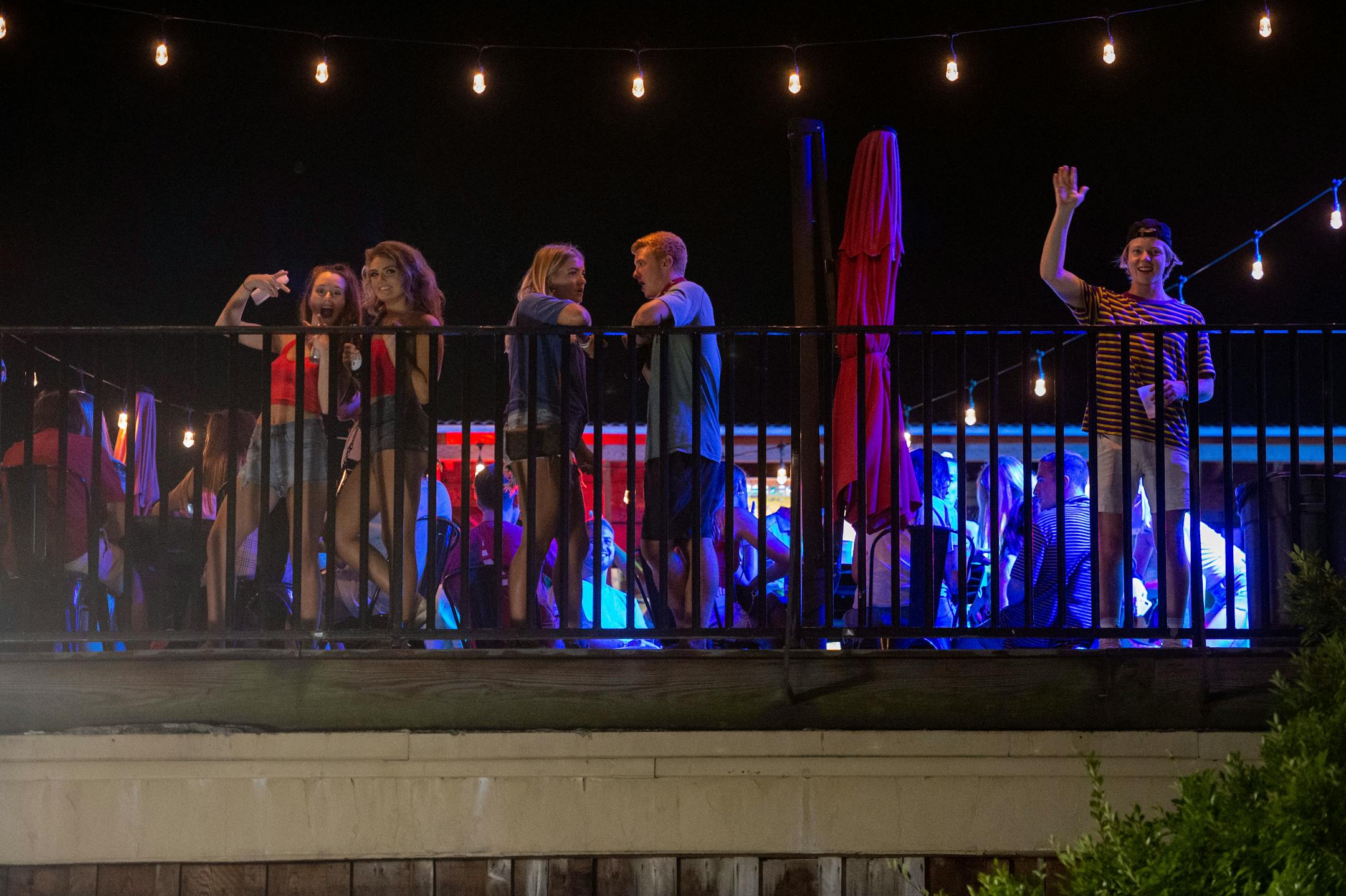 Patrons stood on the Bear Trap's rooftop bar on The Strip, the University of Alabama's bar scene, on Aug. 15, in Tuscaloosa, Ala. More than 20,000 students returned to campus for the first time since spring break, with numerous school and city codes in effect to limit the spread of COVID-19.