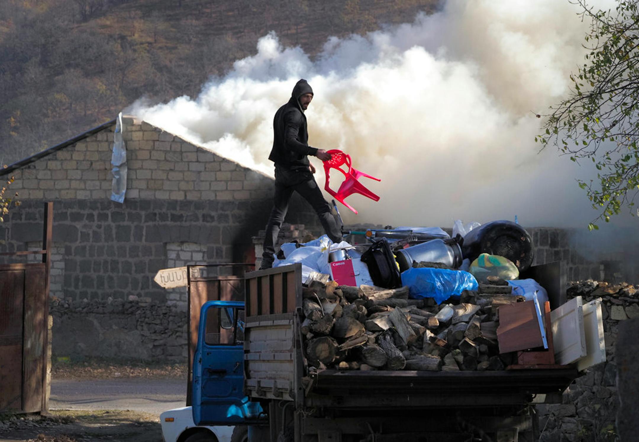 A man loads possessions on his truck after setting his home on fire, in an area once occupied by Armenian forces but is soon to be turned over to Azerbaijan, in Karvachar, the separatist region of Nagorno-Karabakh, on Friday, Nov. 13, 2020.